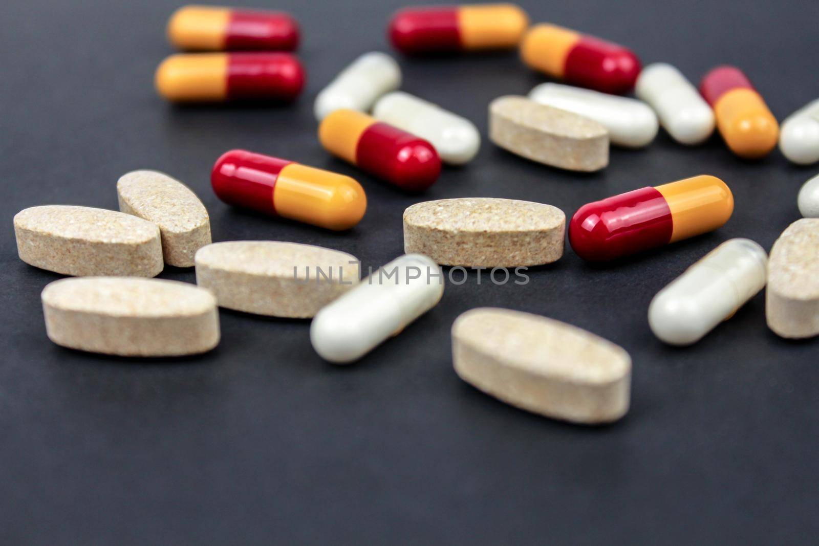 Heap of colorful medication and pills, capsules on black background. Top view, flat lay. by JuliaDorian