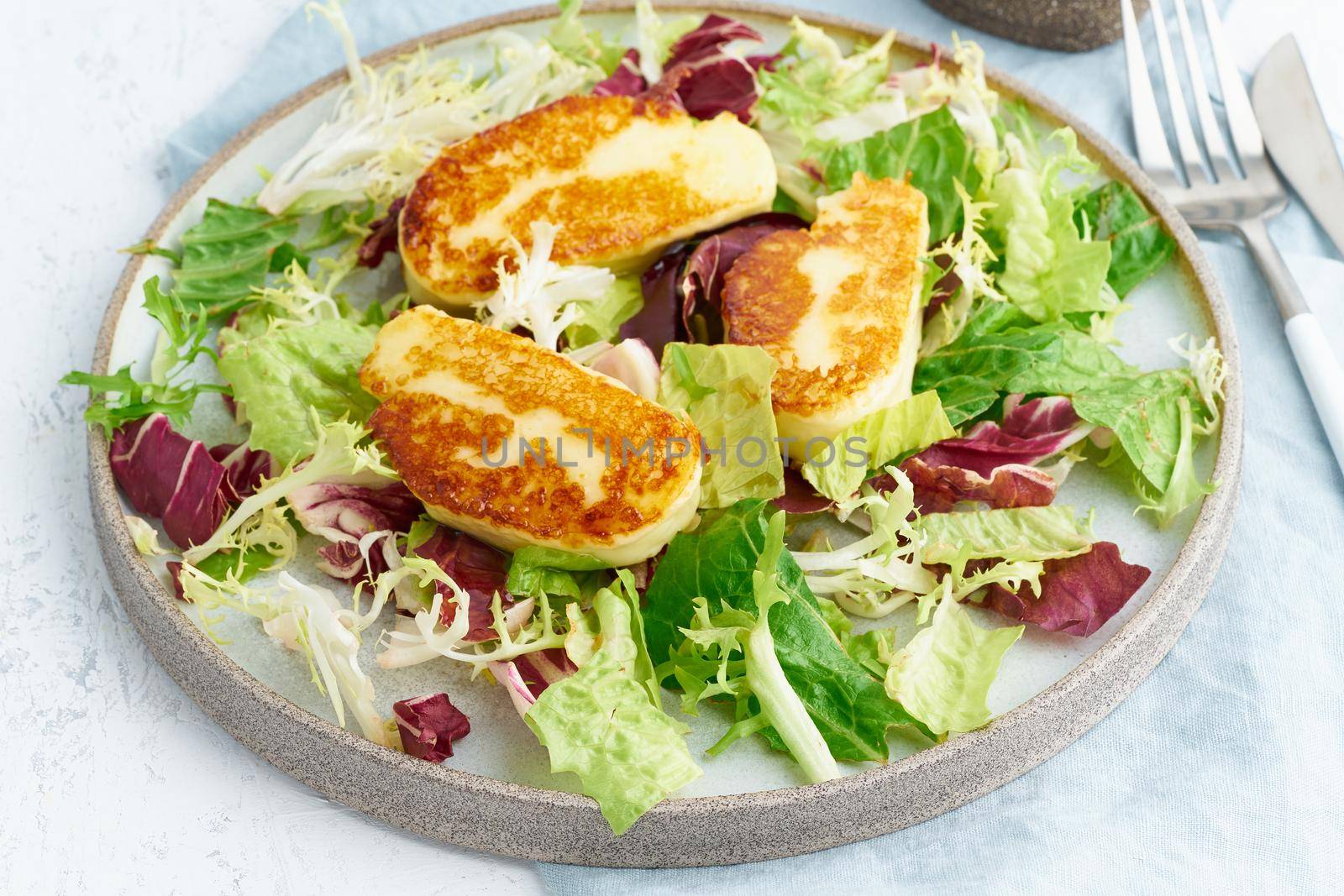 Cyprus fried halloumi with healthy salad mix. Lchf, pegan, fodmap, paleo, scd, keto, ketogenic diet. Balanced food, clean eating recipe. Close up, white background, side view