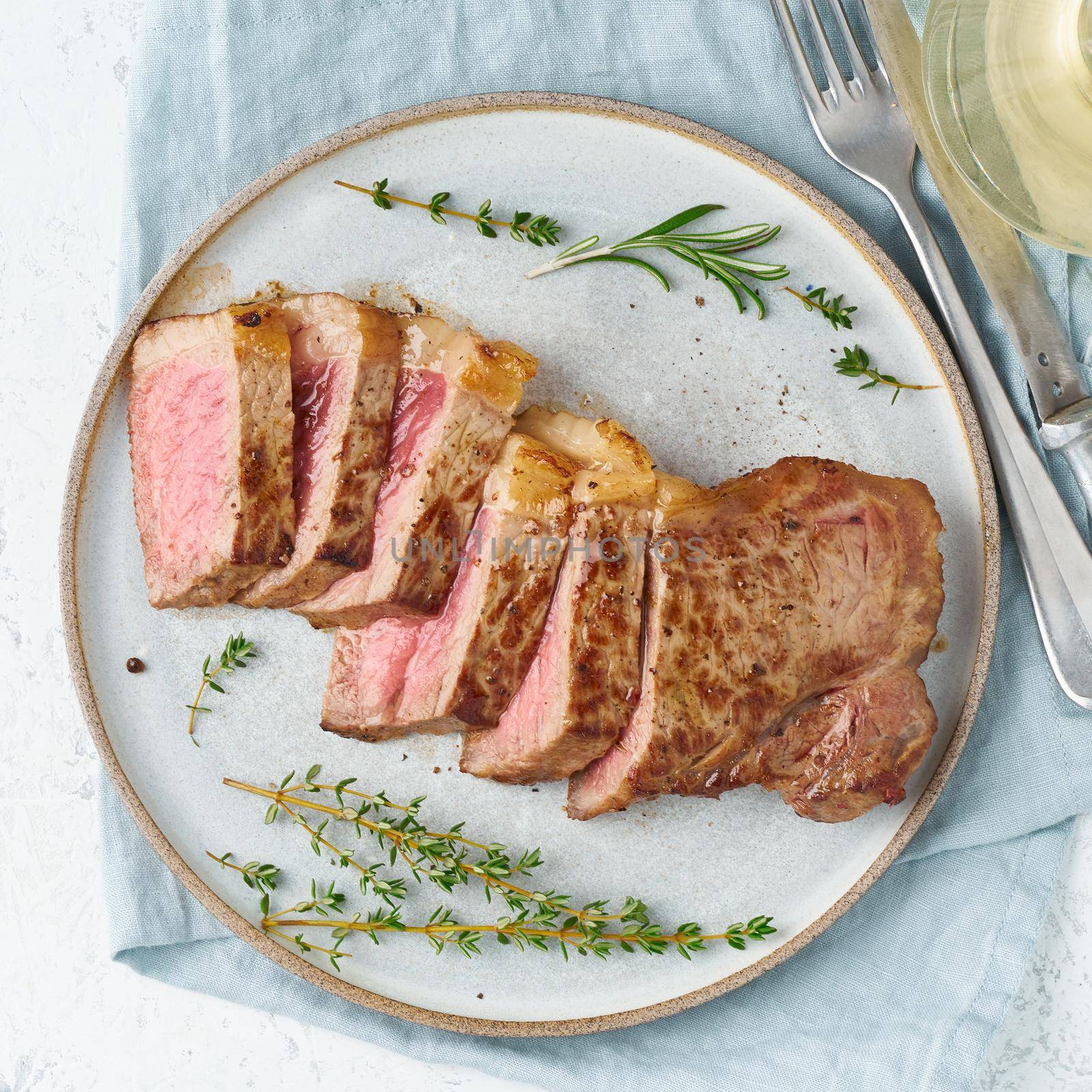 Keto ketogenic diet beef steak, striploin on gray plate on white background. Paleo food by NataBene