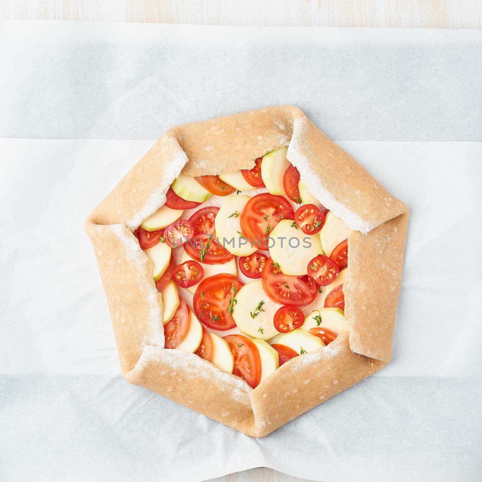 Step by step recipe. Raw homemade galette with vegetable. Top view, white wooden table