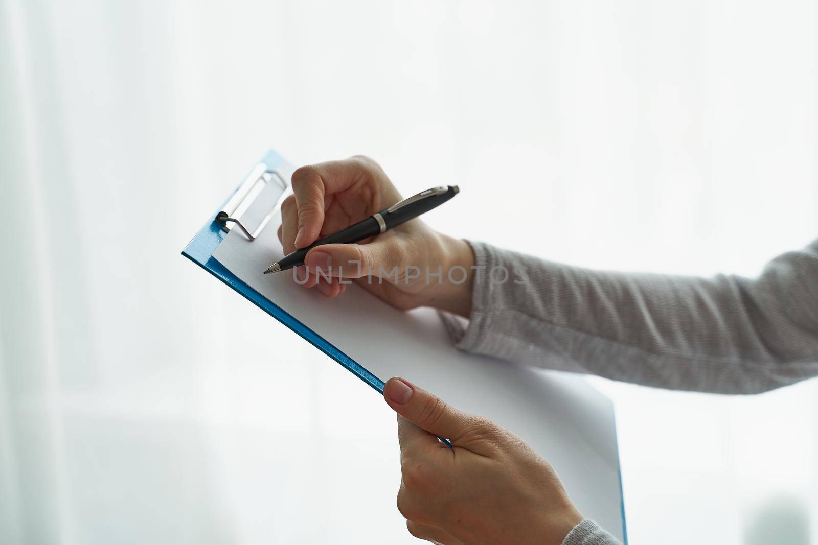 person writing on clipboard with pen, secretary or inspector idea, formal clothes