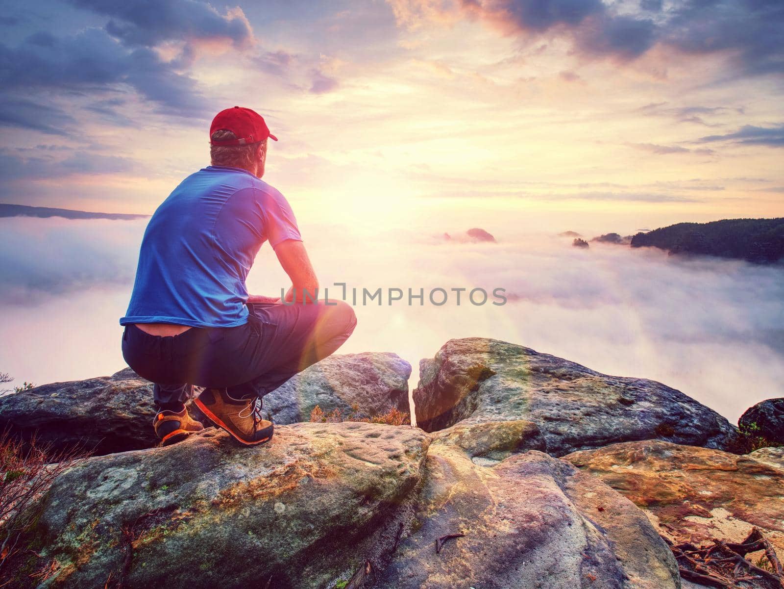 Hiker on sharp cliff of sandstone rock in rock empires park observe misty and foggy spring valley