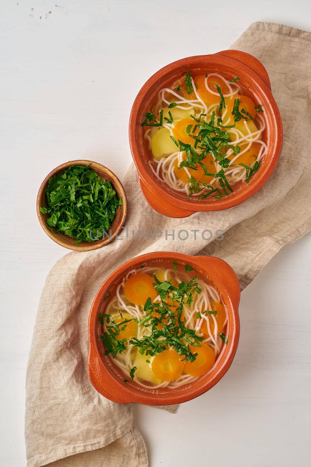Healthy chicken soup with vegetables and rice noodles, fodmap dash diet, top view by NataBene