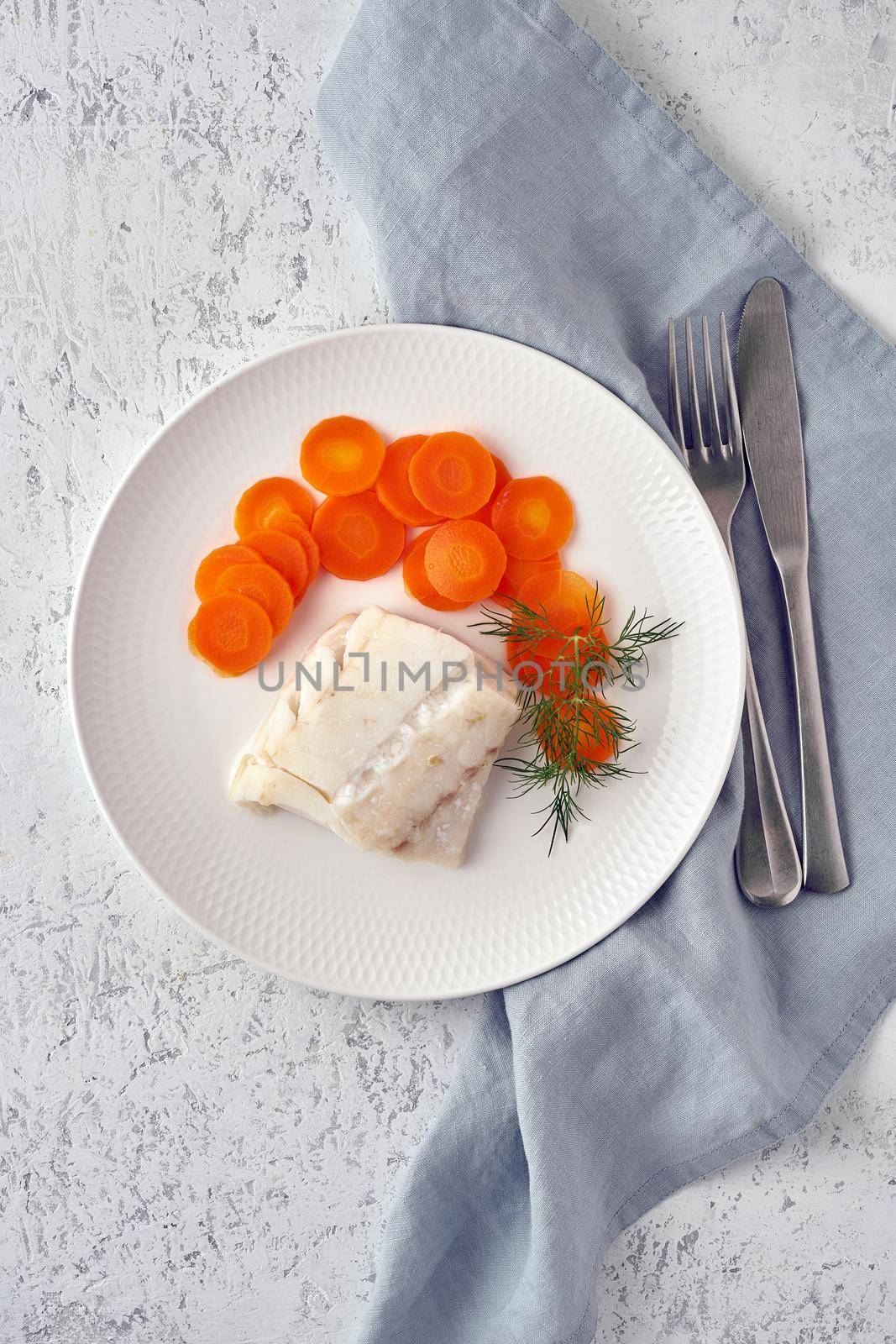Boiled codfish with carrot and dill on white plate, fodmap dash paleo diet by NataBene