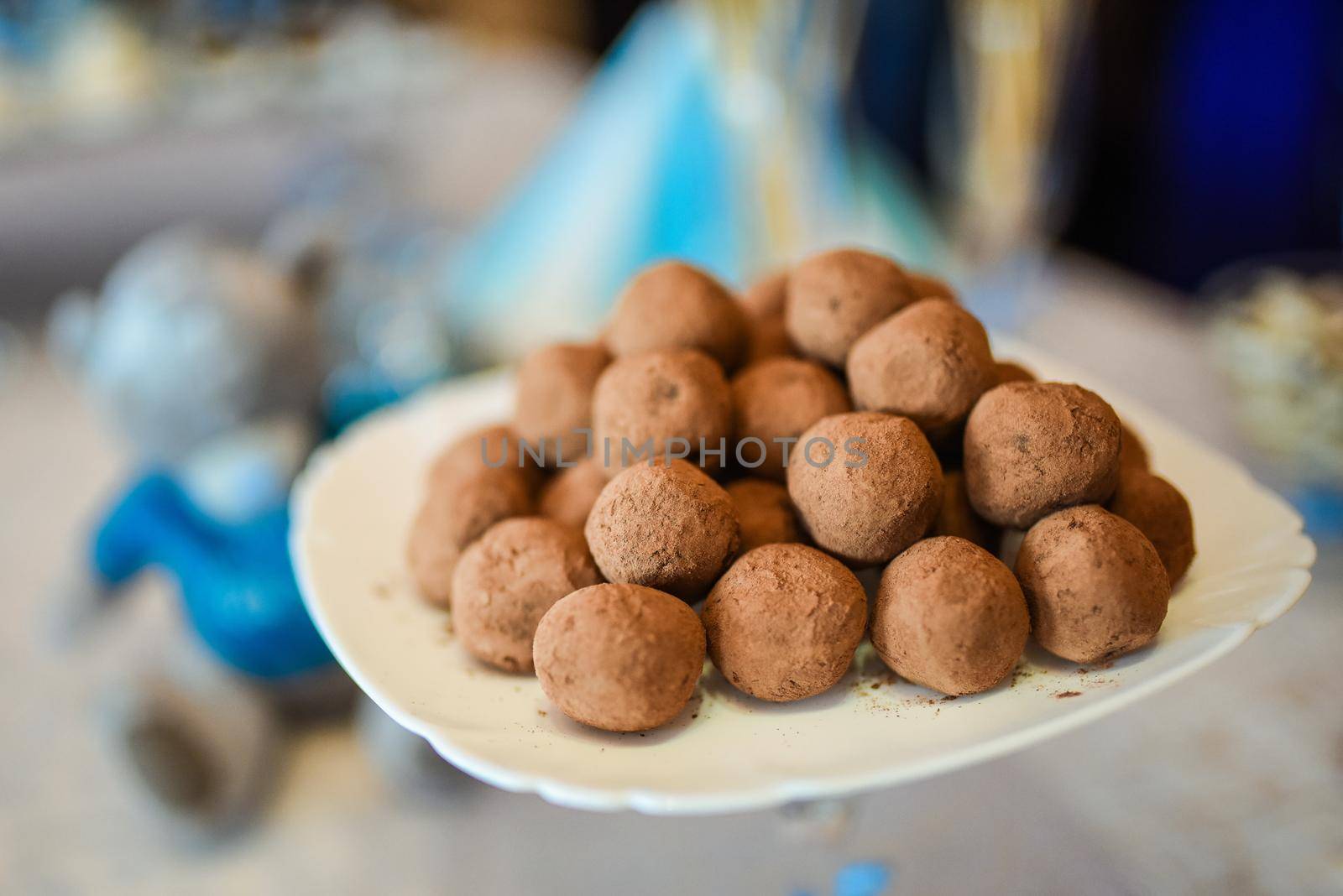 Sweet truffles on a plate covered with cocoa. Food candy. Colorfull delicious.
