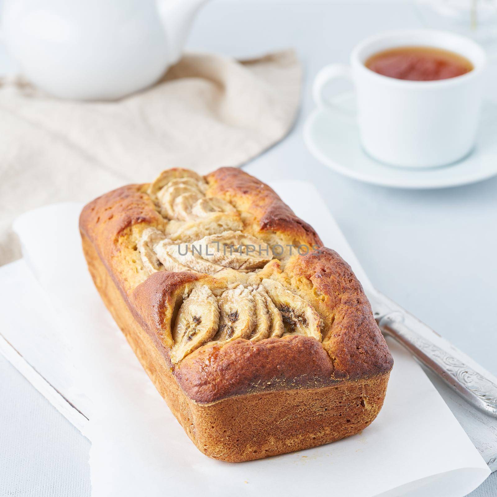 Banana bread, cake with banana, side view. The morning Breakfast with tea on light grey background by NataBene