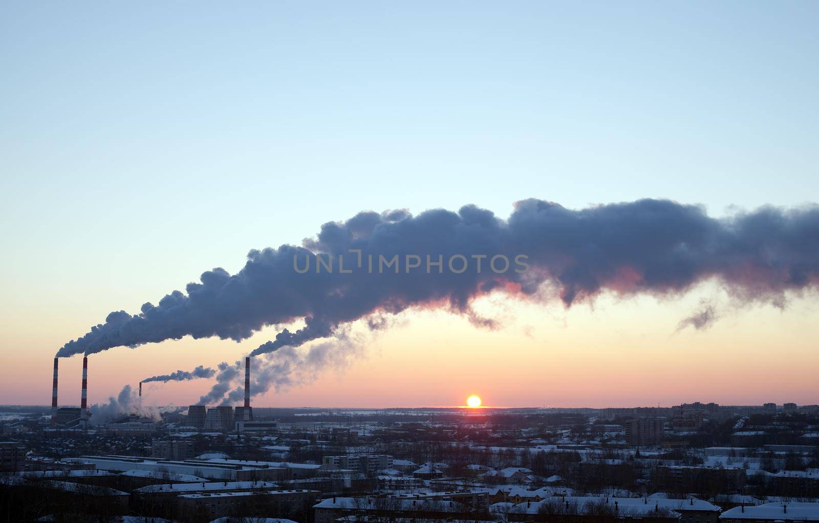 winter industrial sunset with smoke on sky