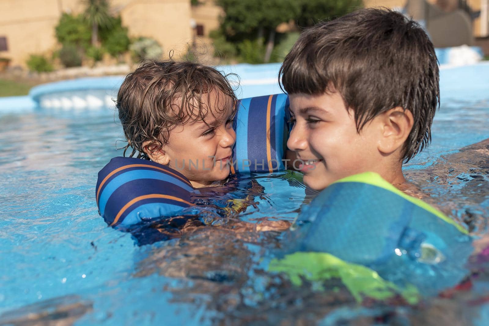 Single-parent family playing in the swimming pool. Summer arrives in the northern hemisphere