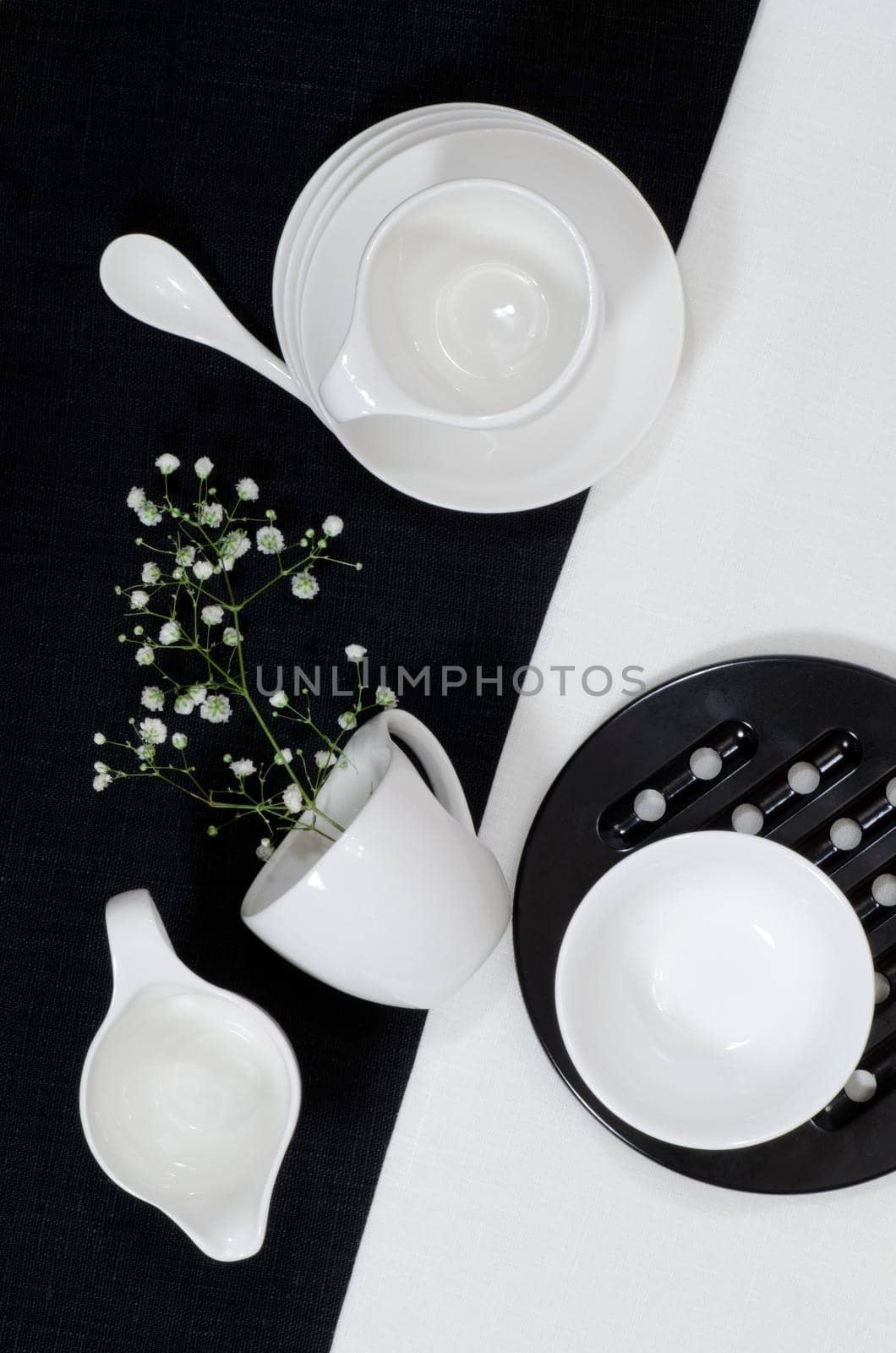 White porcelain on black and white linen tablecloths. White porcelain on black and white linen tablecloths. Abstract still life. From series "Playing with Color"