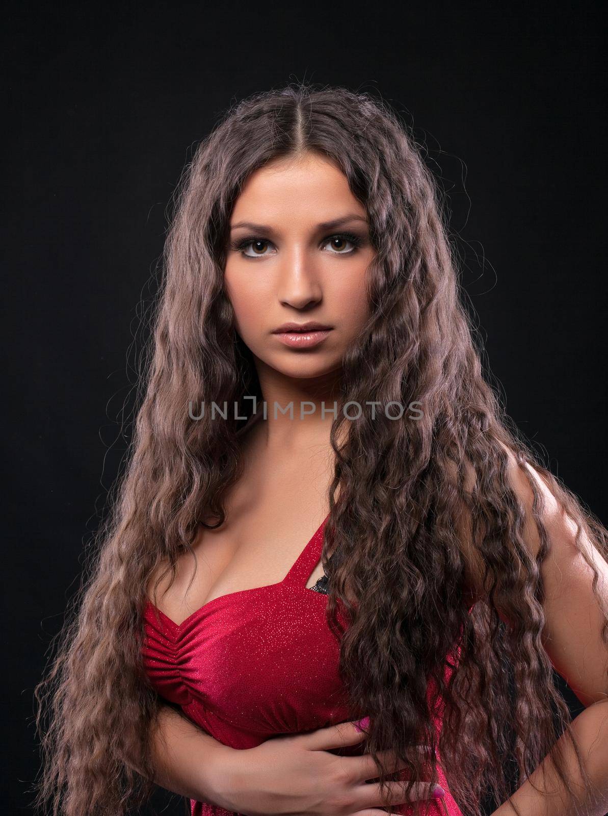 Young amazing girl with curly hair in red by rivertime