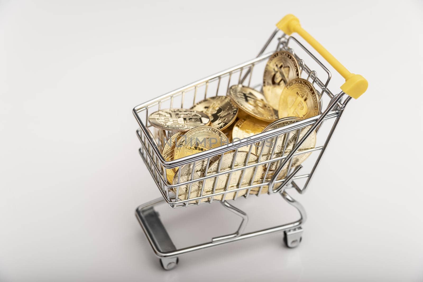 Side view of bitcoin and shopping cart on white background. Buying or selling the cryptocurrency concept. Virtual money, cryptocurrency. E-commerce concept. by jbruiz78