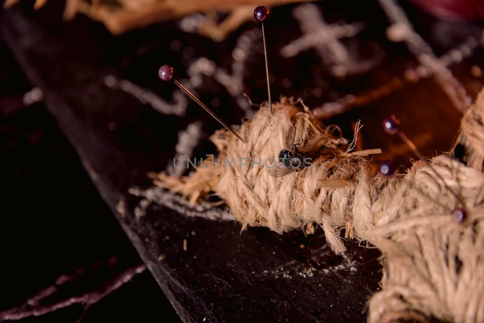 Voodoo Magic concept. Voodoo doll studded with needles with pierced rag heart on pentagram and around burning candles. Spooky or eerie magical esoteric ritua