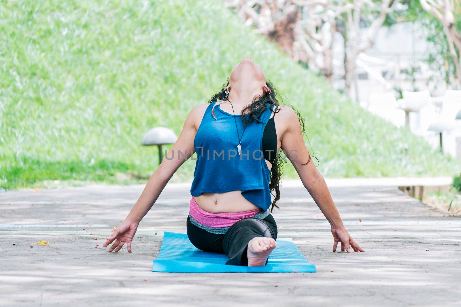 Girl sitting doing split meditation yoga outdoors, woman doing side split yoga outdoors, young woman doing side split yoga by isaiphoto