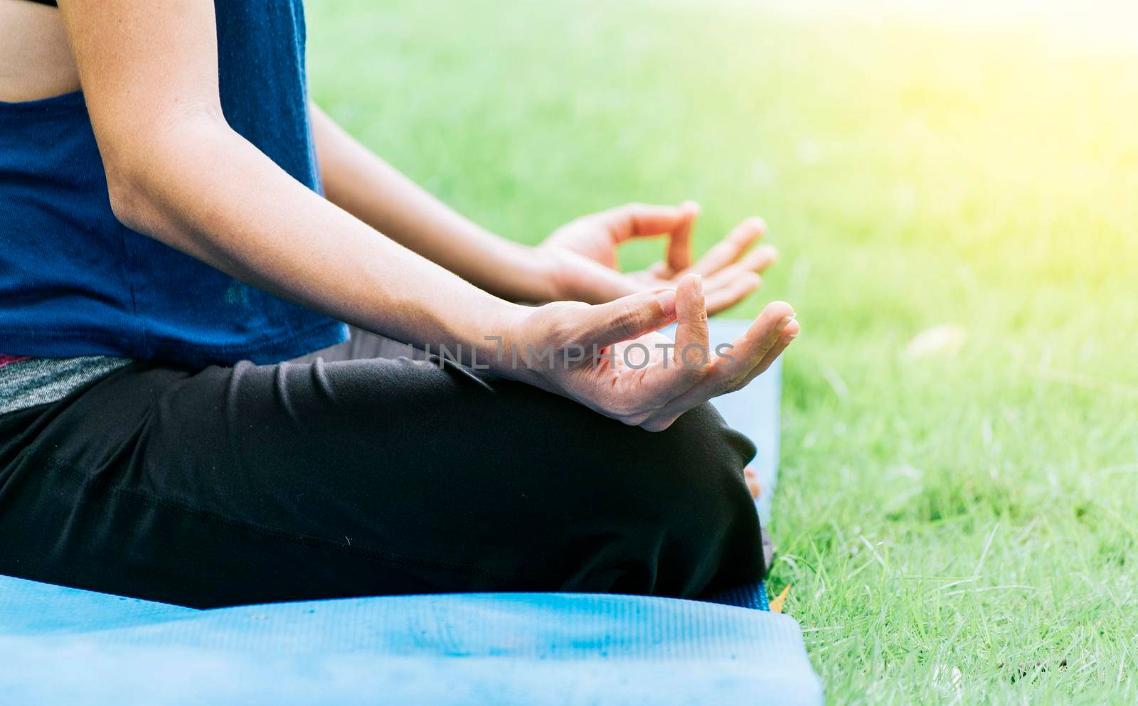 Close up of hands of a girl doing meditation yoga outdoors, Close up of hands doing yoga on the grass