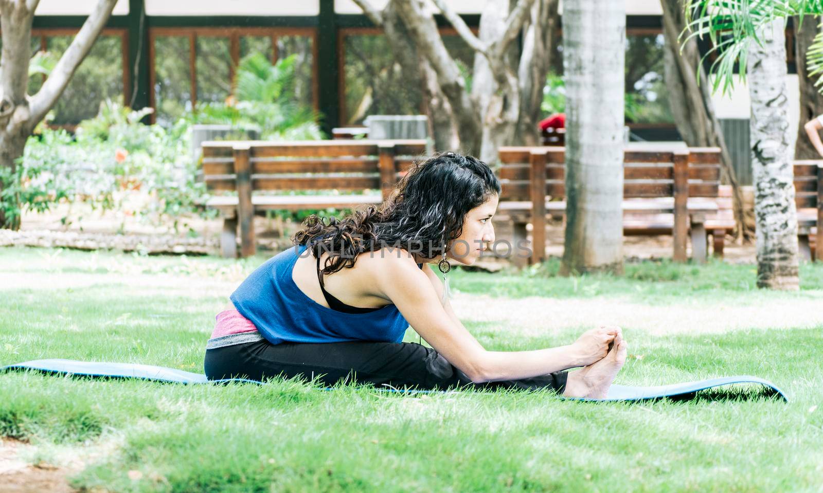 A girl doing stretching yoga, girl doing bharata yoga, young woman doing stretching yoga outdoors