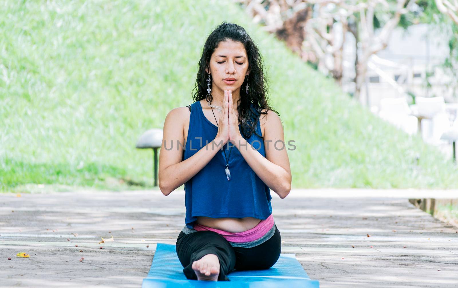 Girl sitting doing split meditation yoga outdoors, woman doing side split yoga outdoors, young woman doing side split yoga by isaiphoto