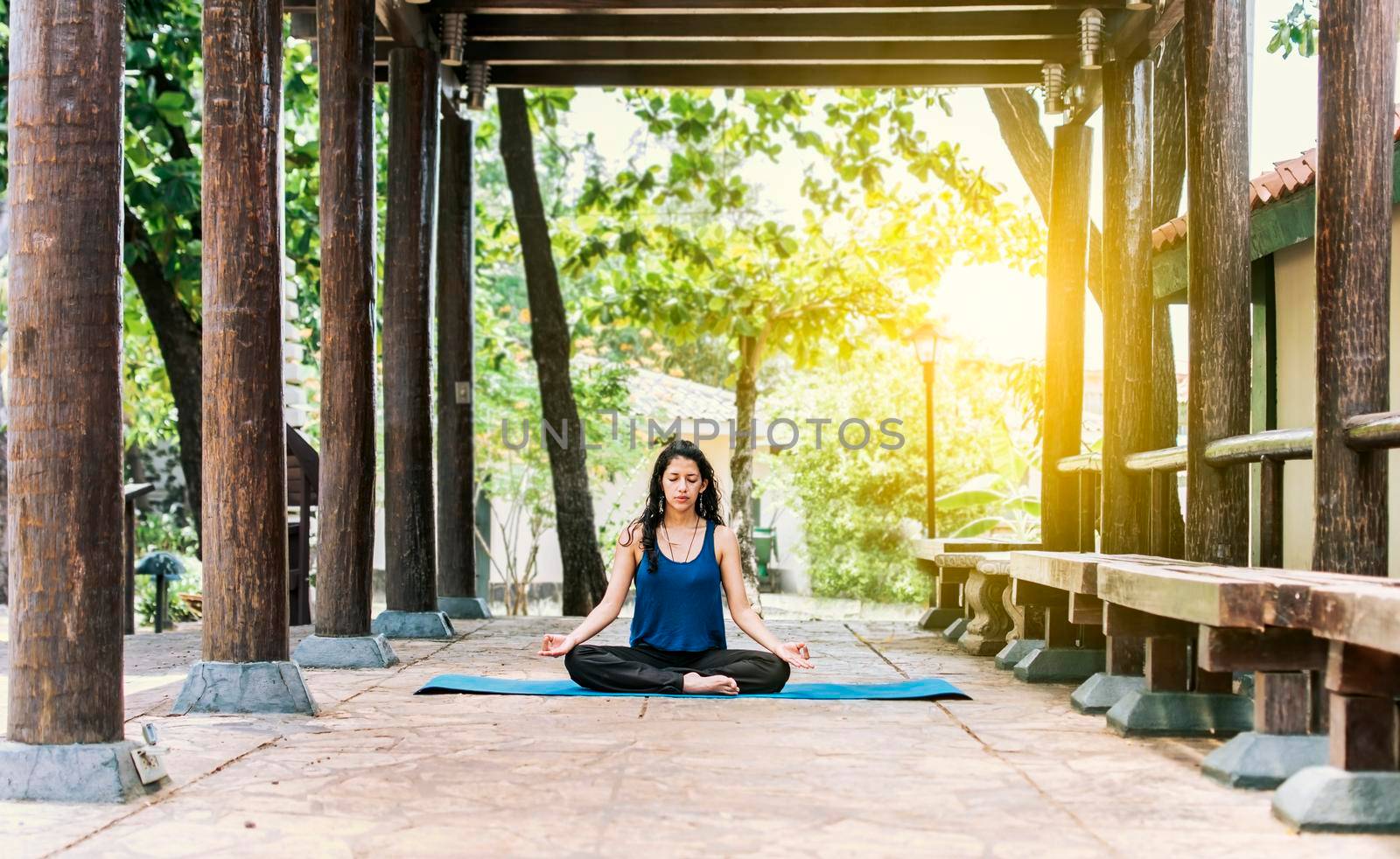 A girl sitting doing meditation yoga outdoors, Woman doing yoga outdoors, a young woman doing yoga with closed eyes.