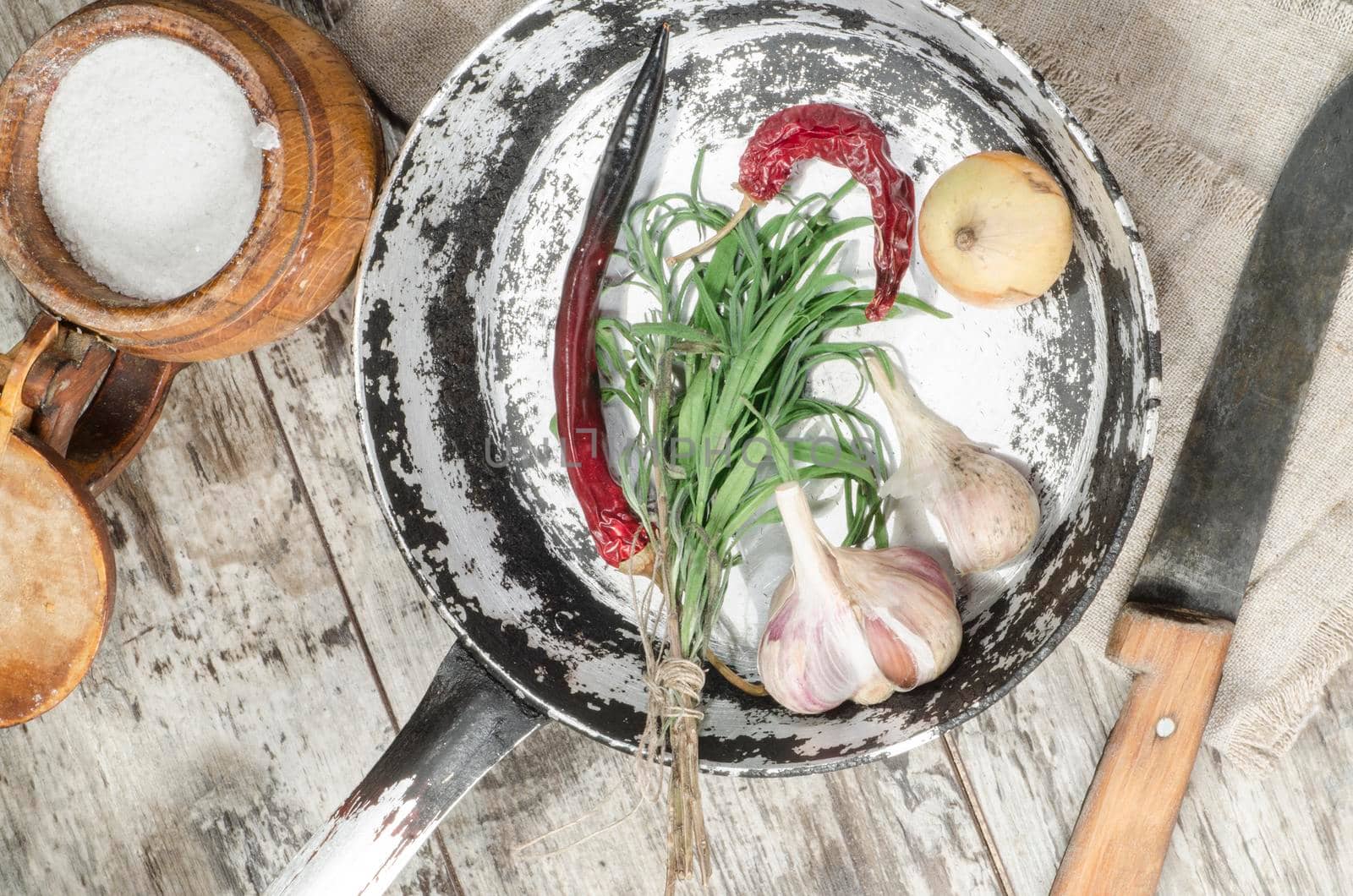 Old pan with vegetabeles on wooden tables, near the old cutlery. From the series "Still Life with fresh fish"