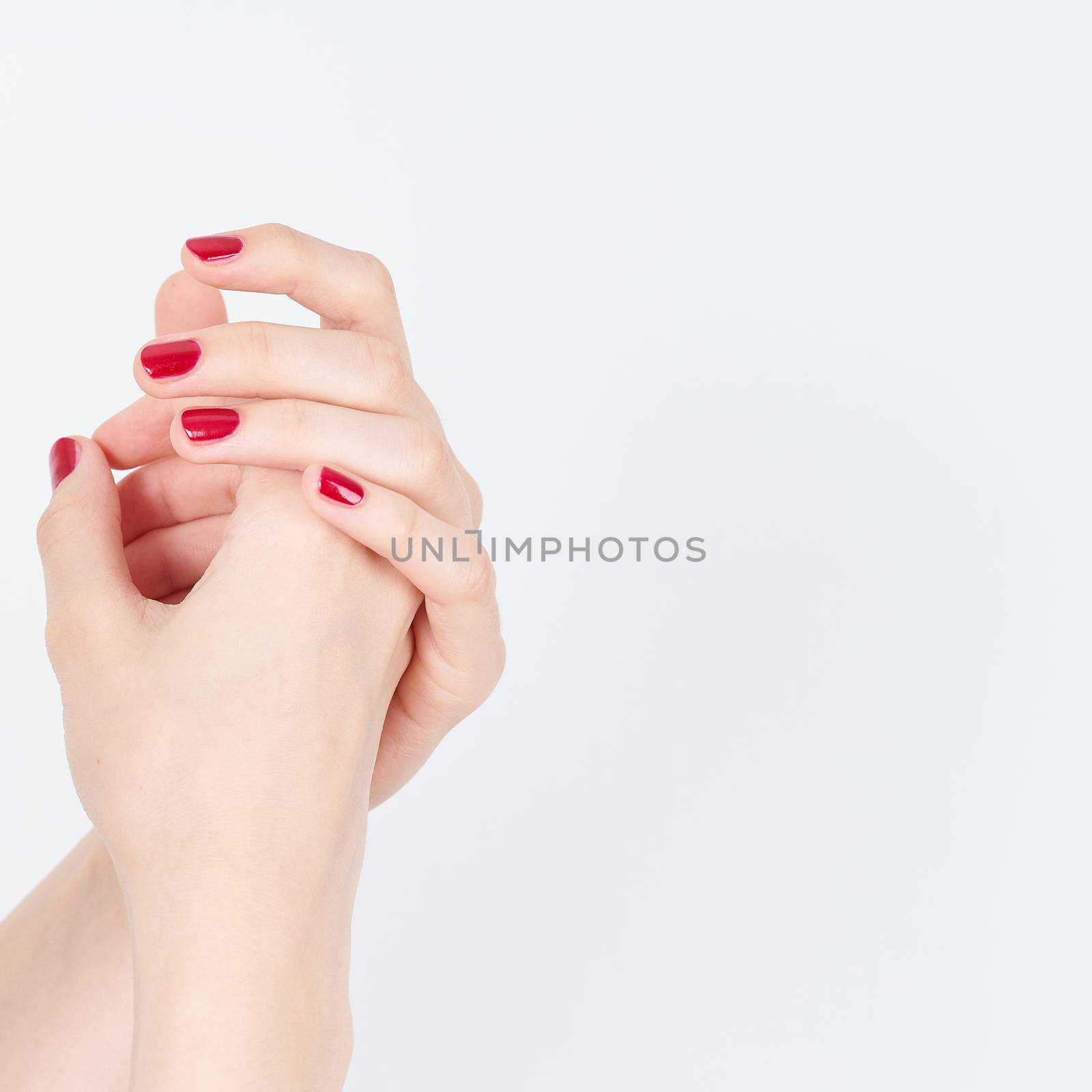 woman showing manicures hands with red nail polish on white background copy space by NataBene