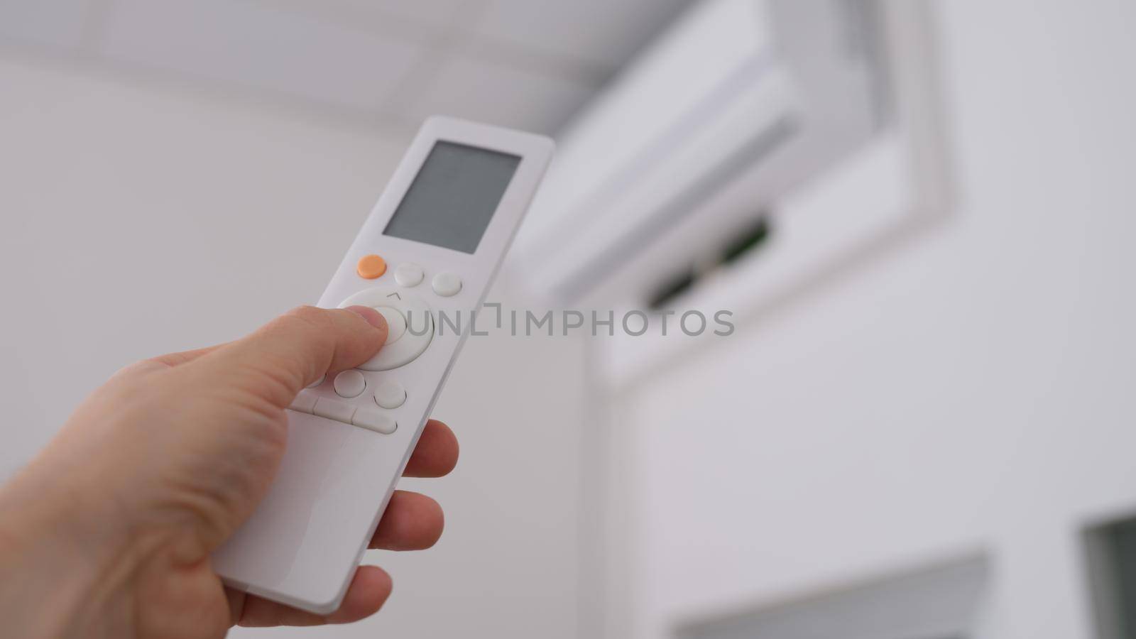 Person is holding air conditioner remote control by kuprevich