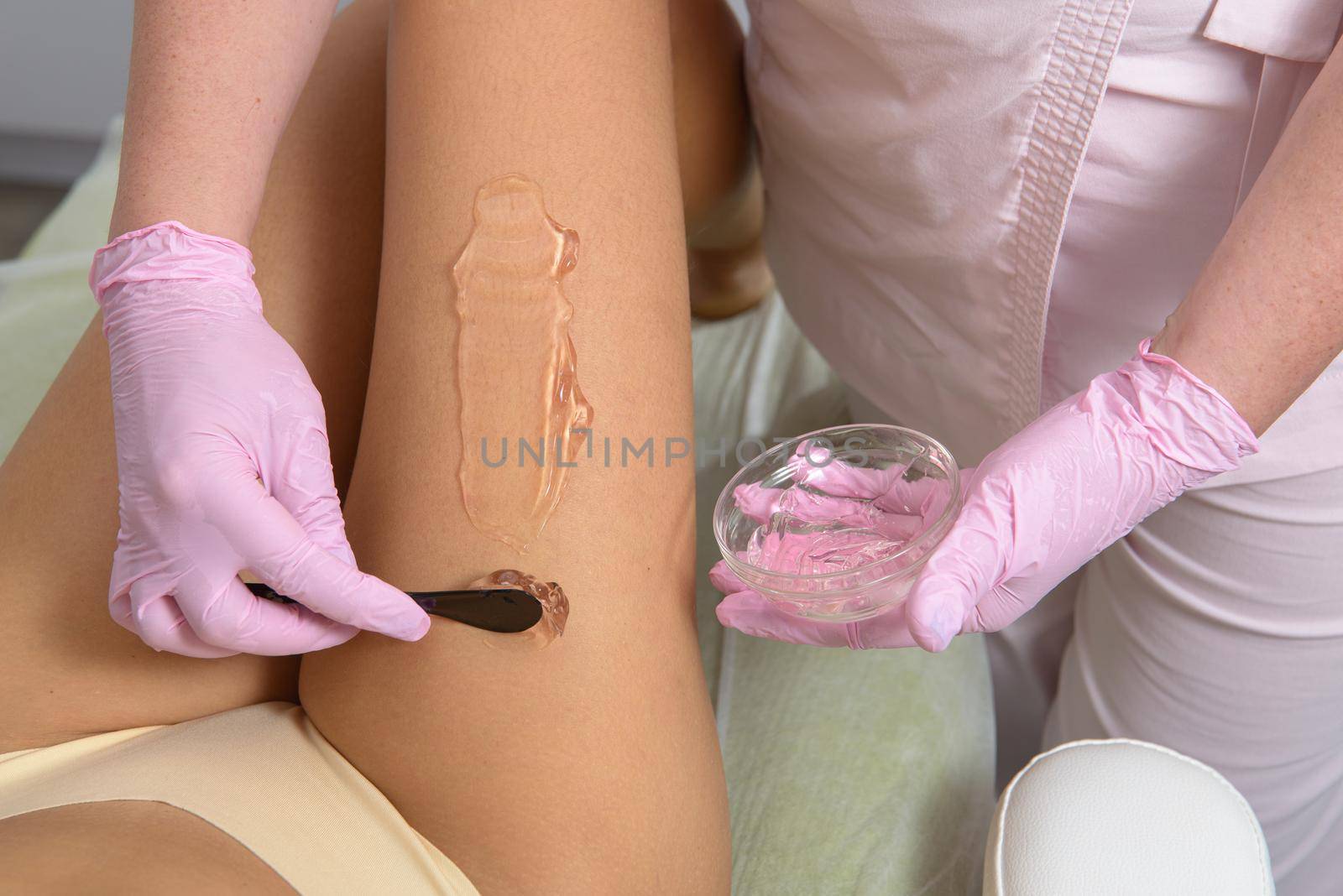 woman beautician applies contact gel on the leg of a woman for laser hair removal in medical clinic. Close up by Ashtray25