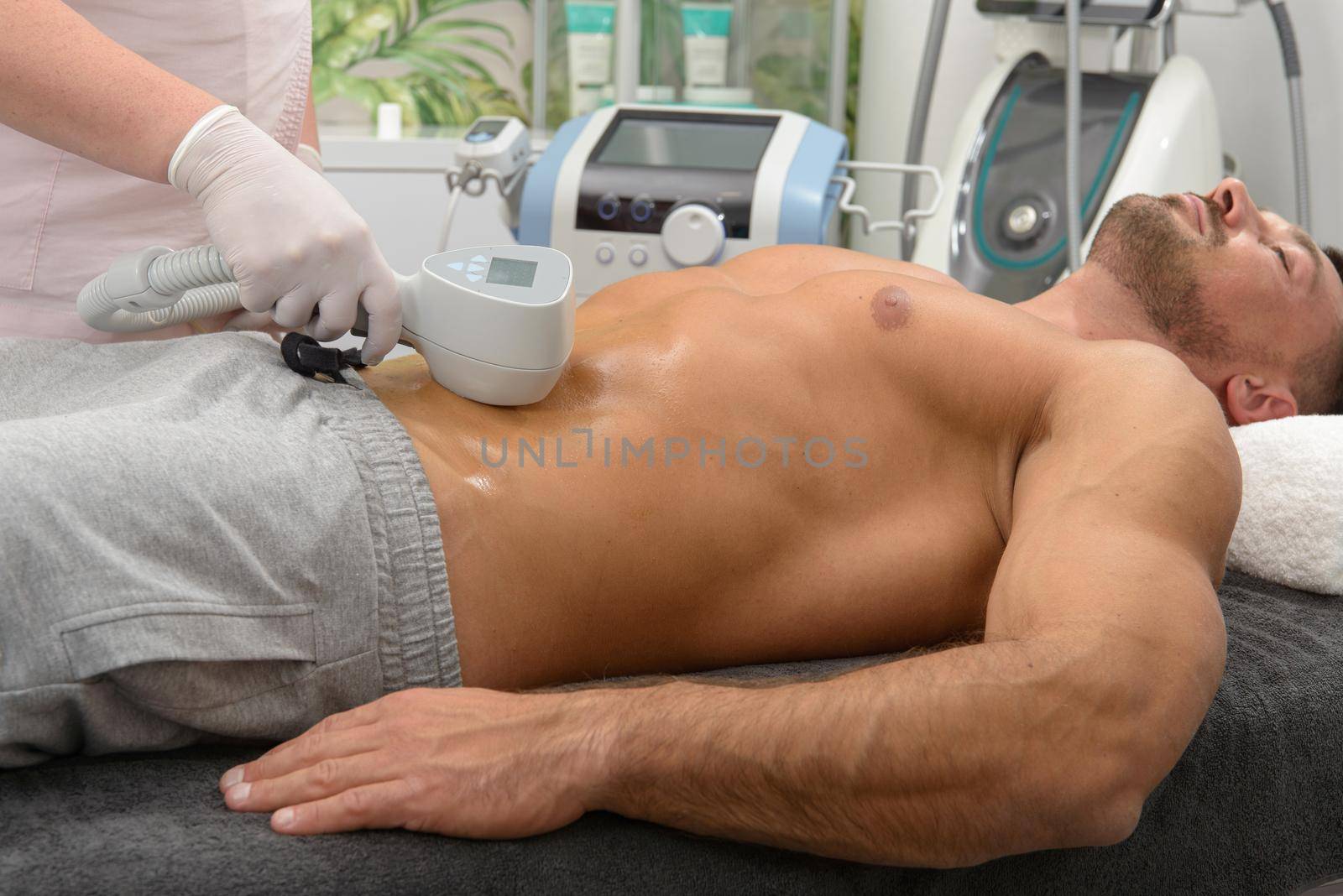 Laser hair removal on mans belly. Doctor and patient in clinic. by Ashtray25