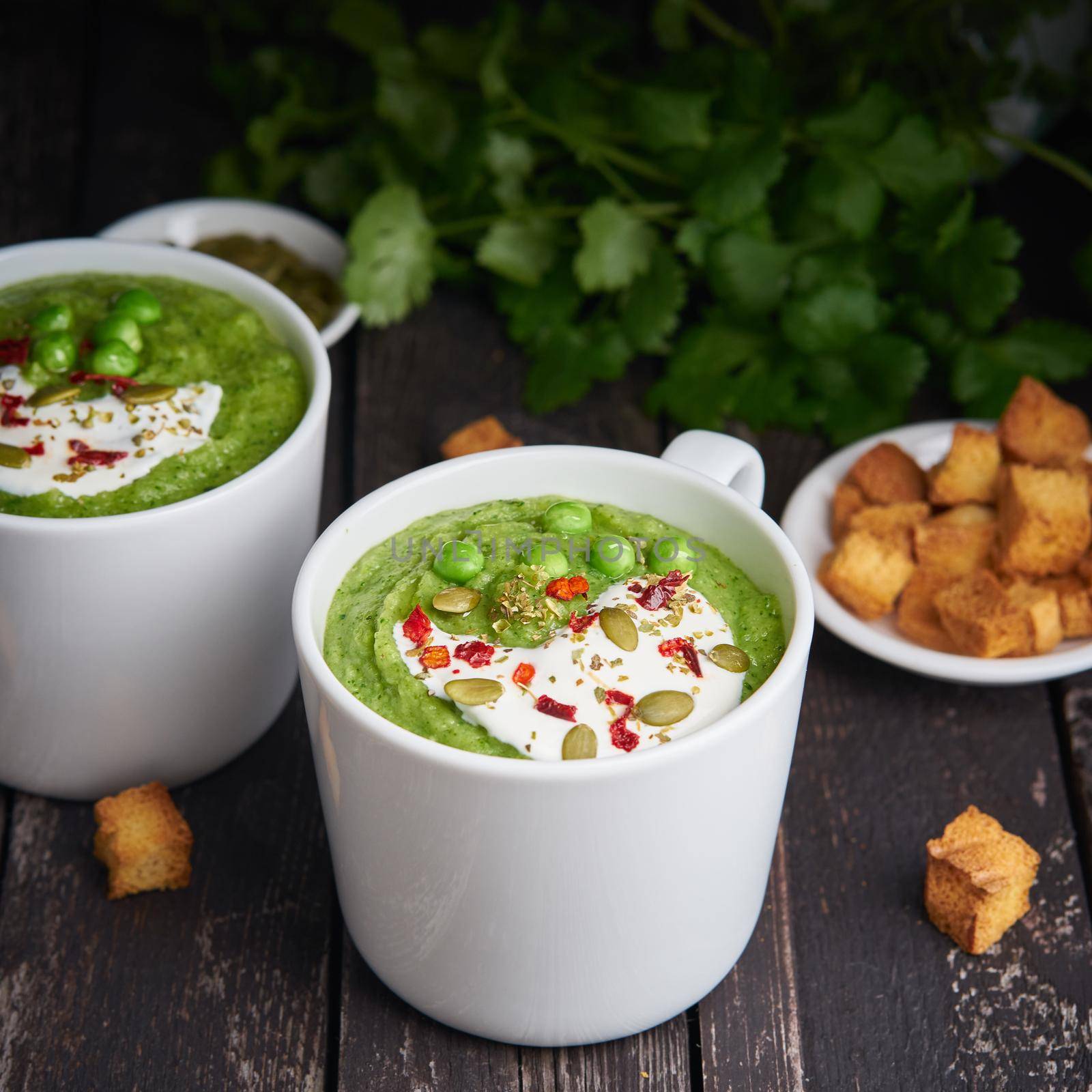 Broccoli cream soup on dark wooden background. Vegetable green puree by NataBene