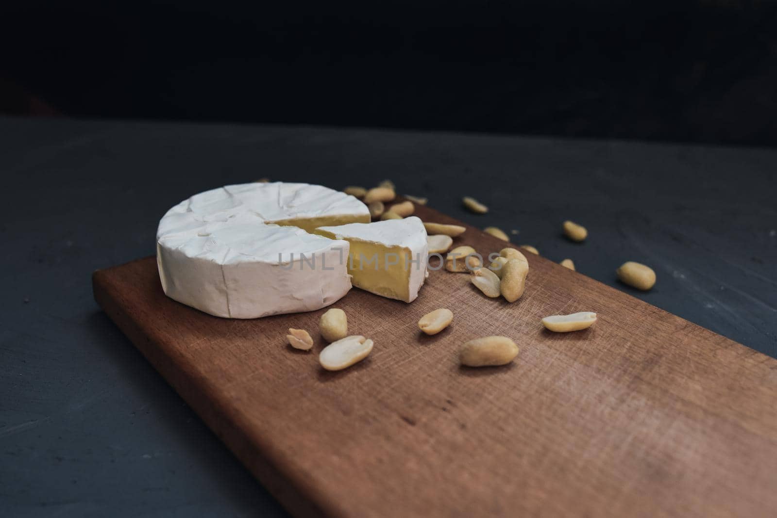 cheese camembert with mold and nuts on the wooden cutting board