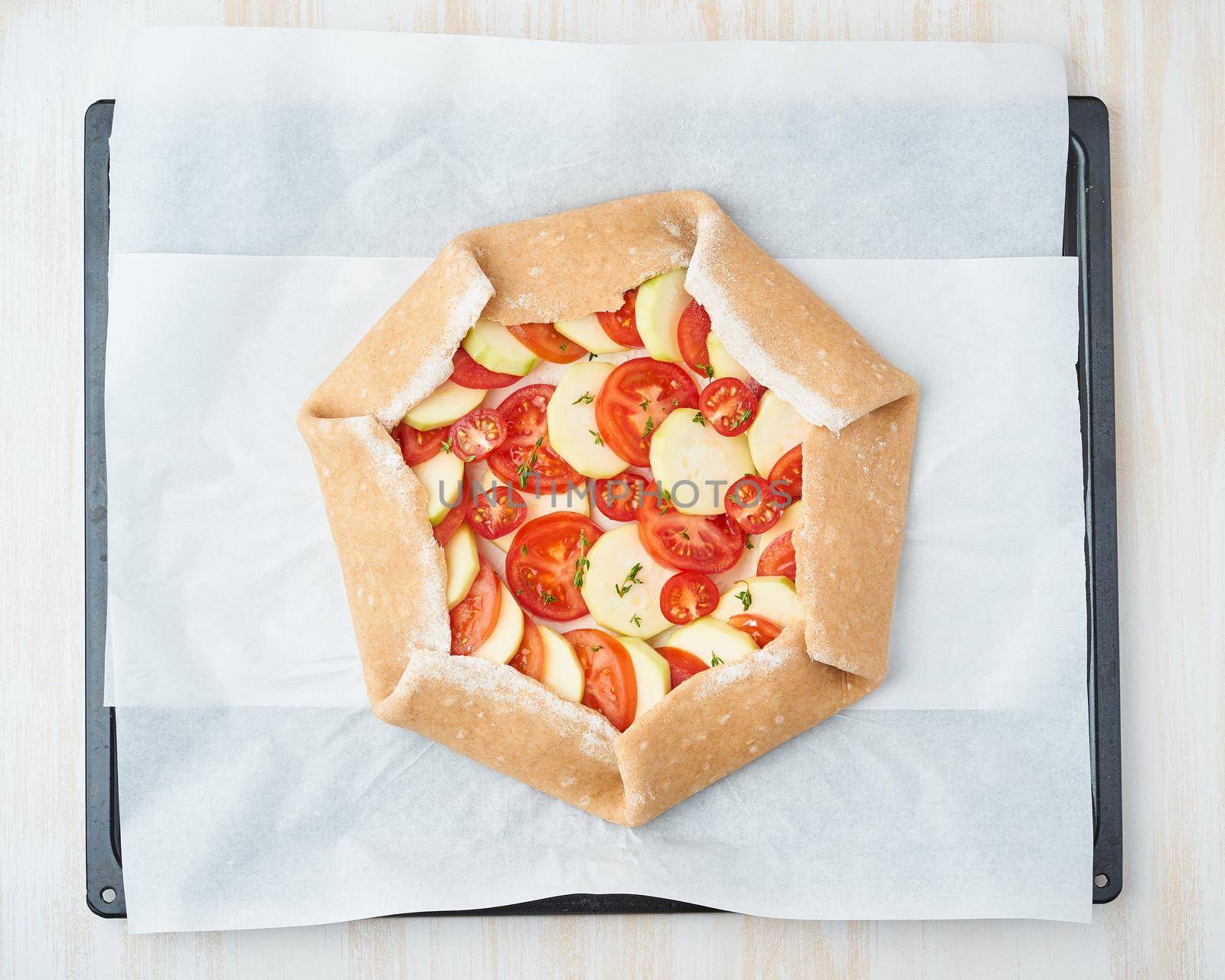 Step by step recipe. Raw homemade galette with vegetable. Top view, white wooden table