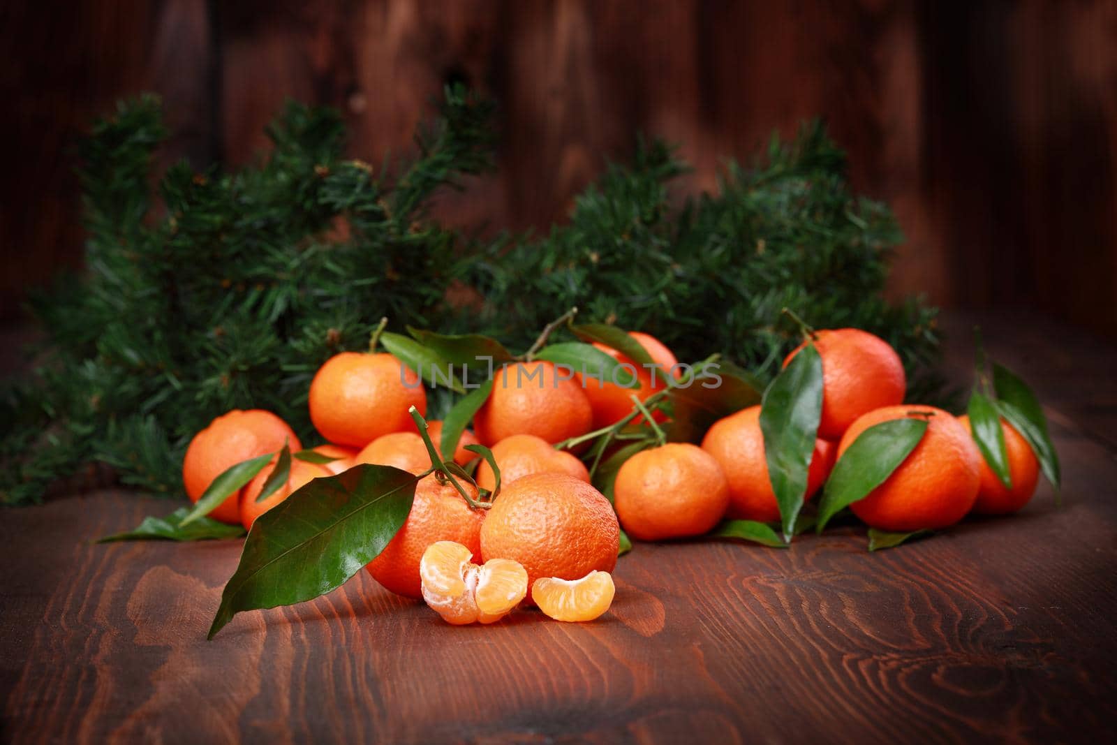 Tangerines with leaves on wooden surface. Citrus fruit