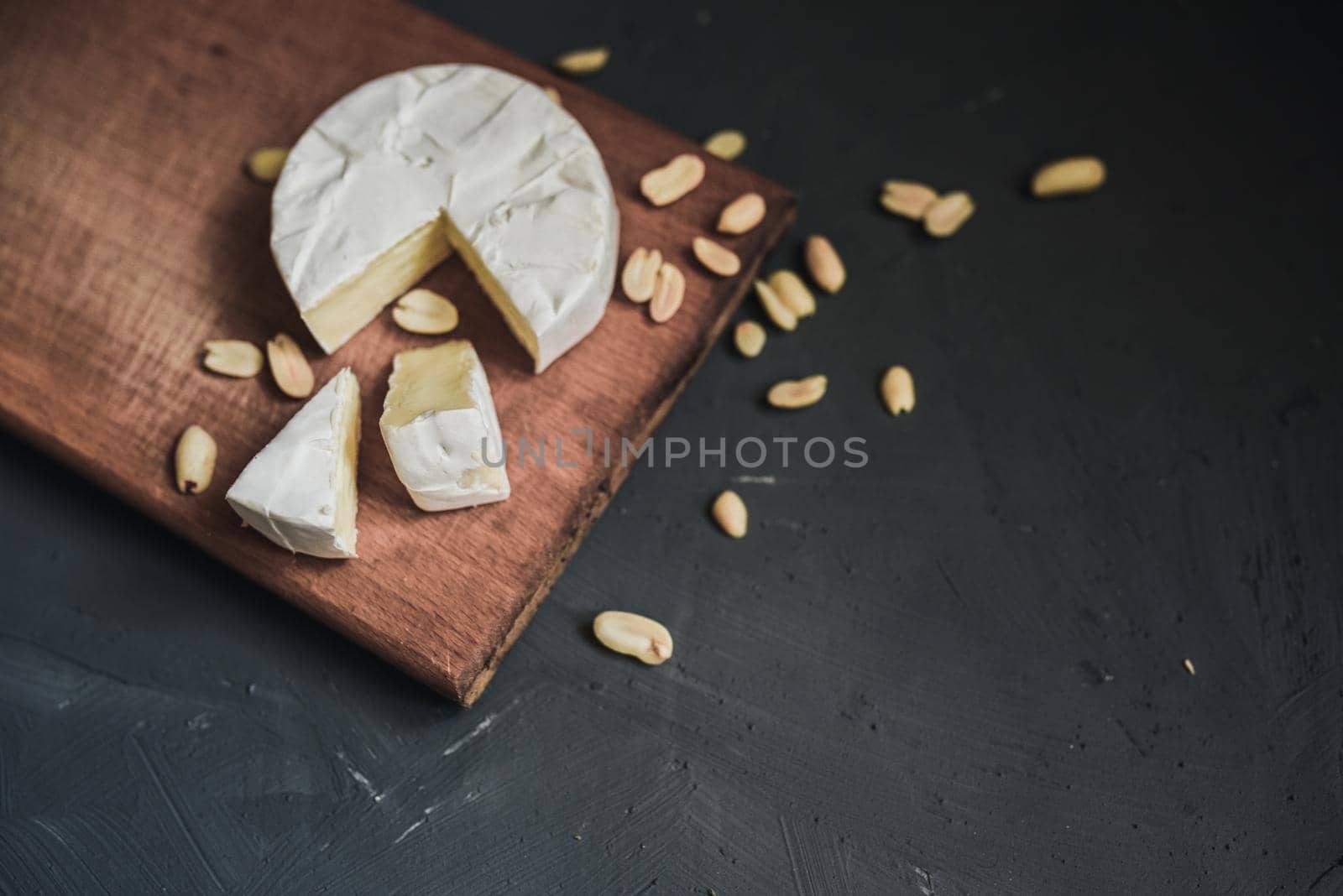 cheese camembert with mold and nuts on the wooden cutting board