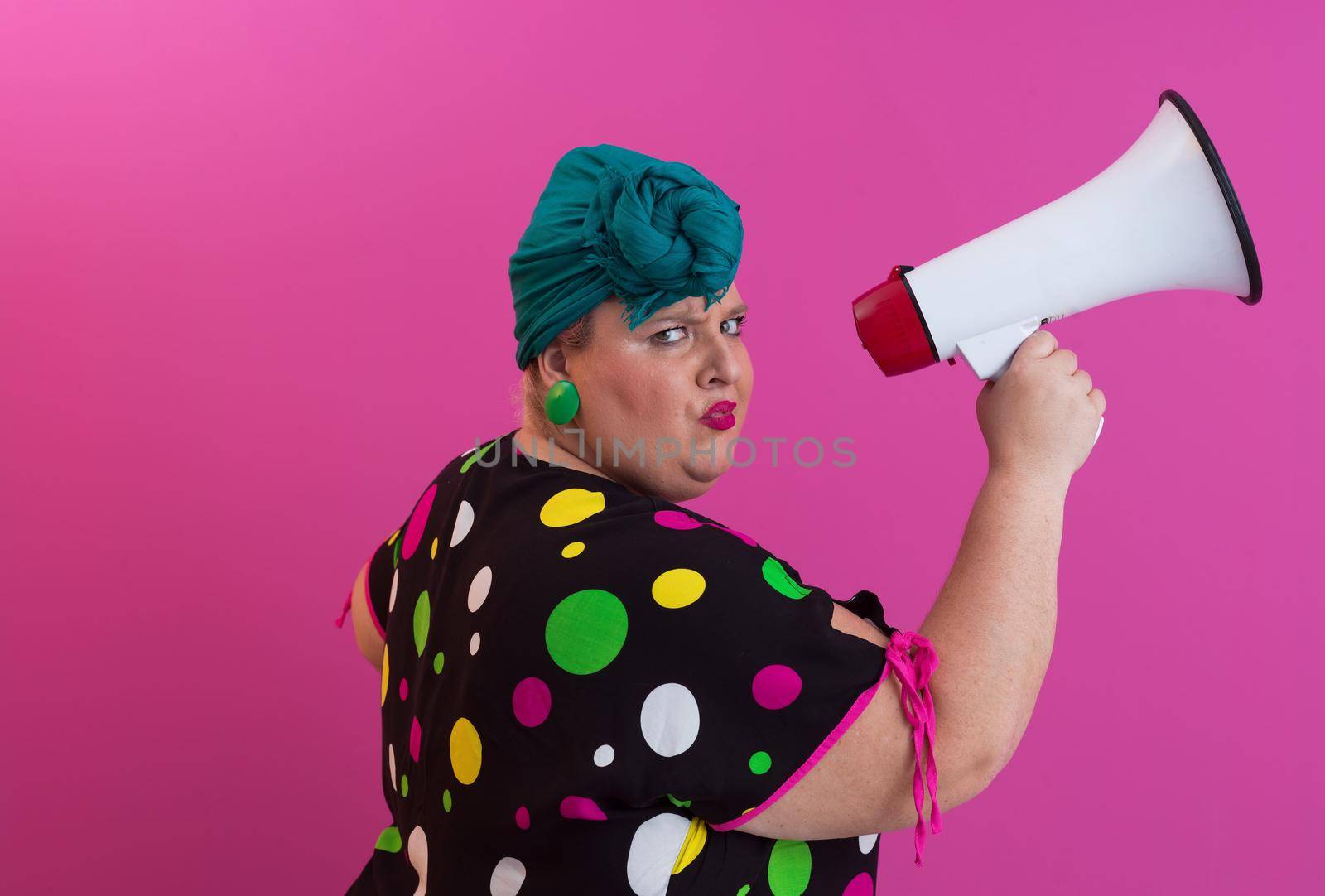 Funny plus size woman woman posing isolated on pink background studio portrait. People emotions lifestyle concept. Mock up copy space. Screaming in megaphone. High quality photo