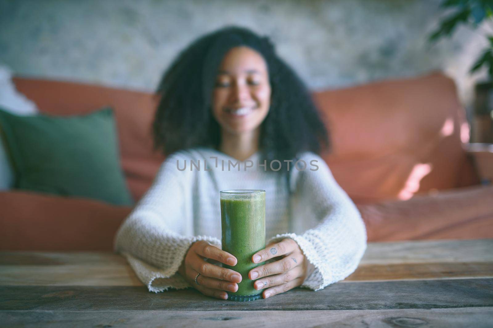 Portrait of you african girl smiling at her green smoothie in her hand