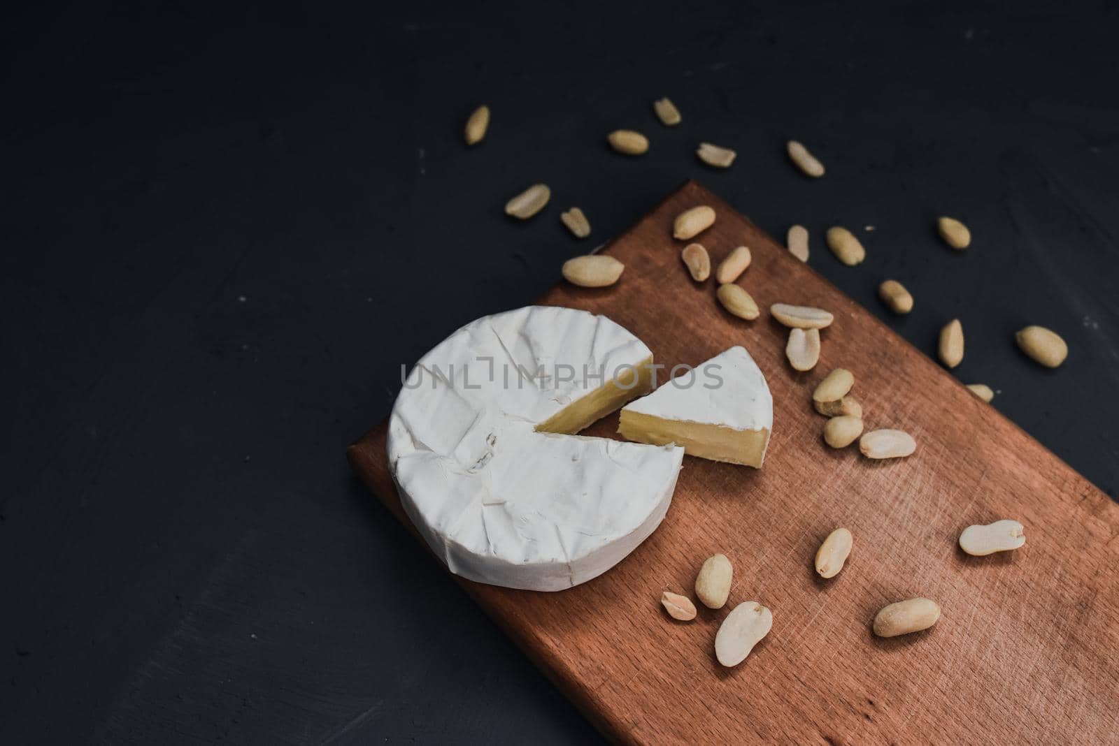 cheese camembert with mold and nuts on the wooden cutting board