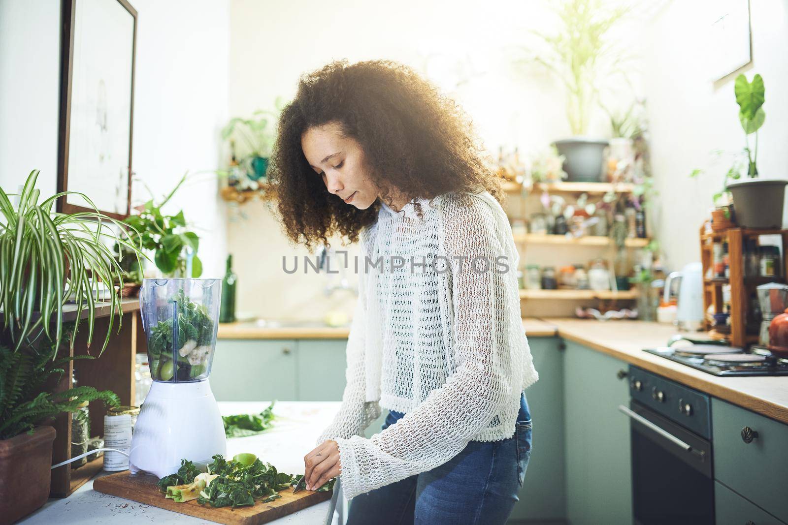 Beautiful african woman making a smoothie for breakfast. High quality photo