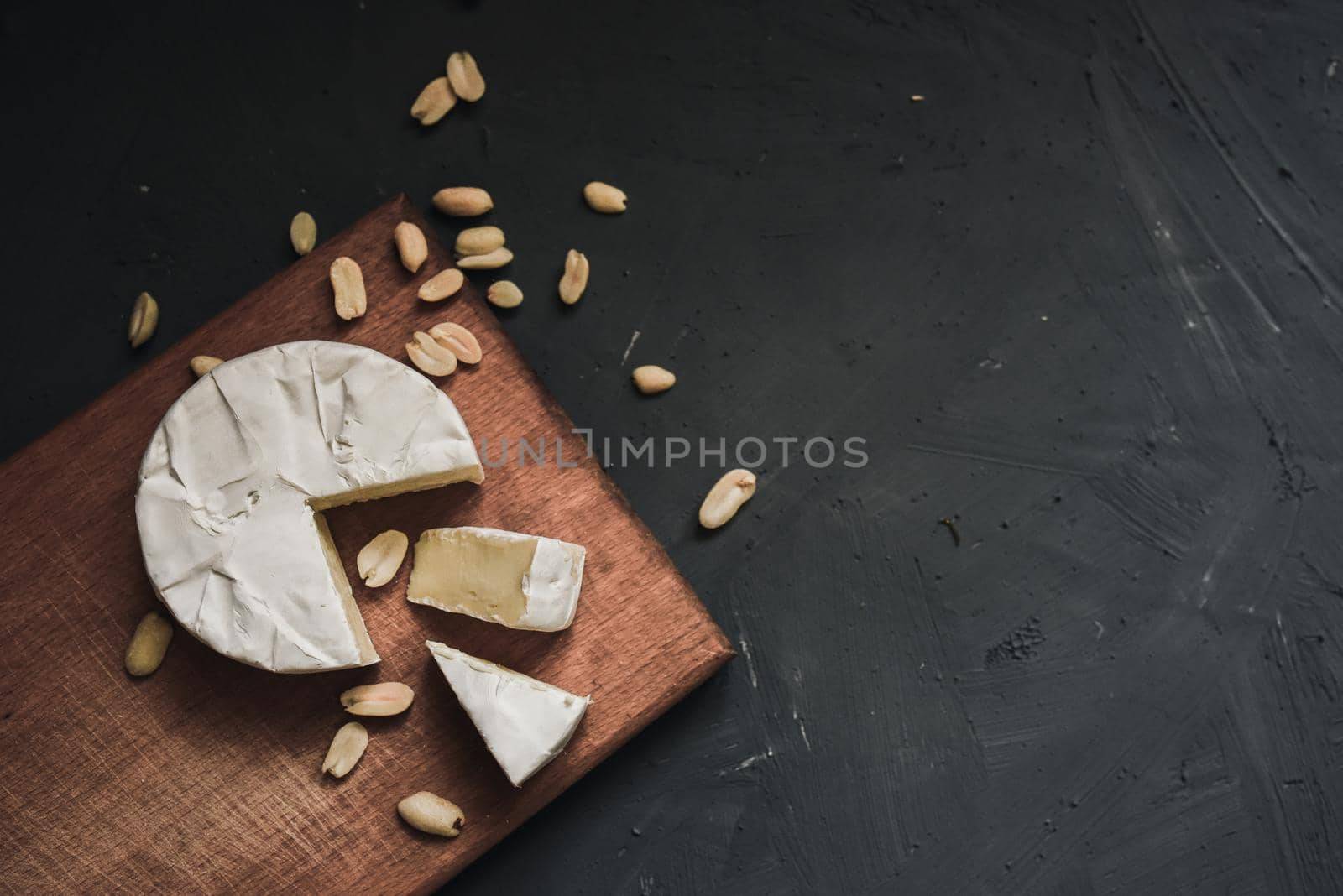 cheese camembert with mold and nuts on the wooden cutting board