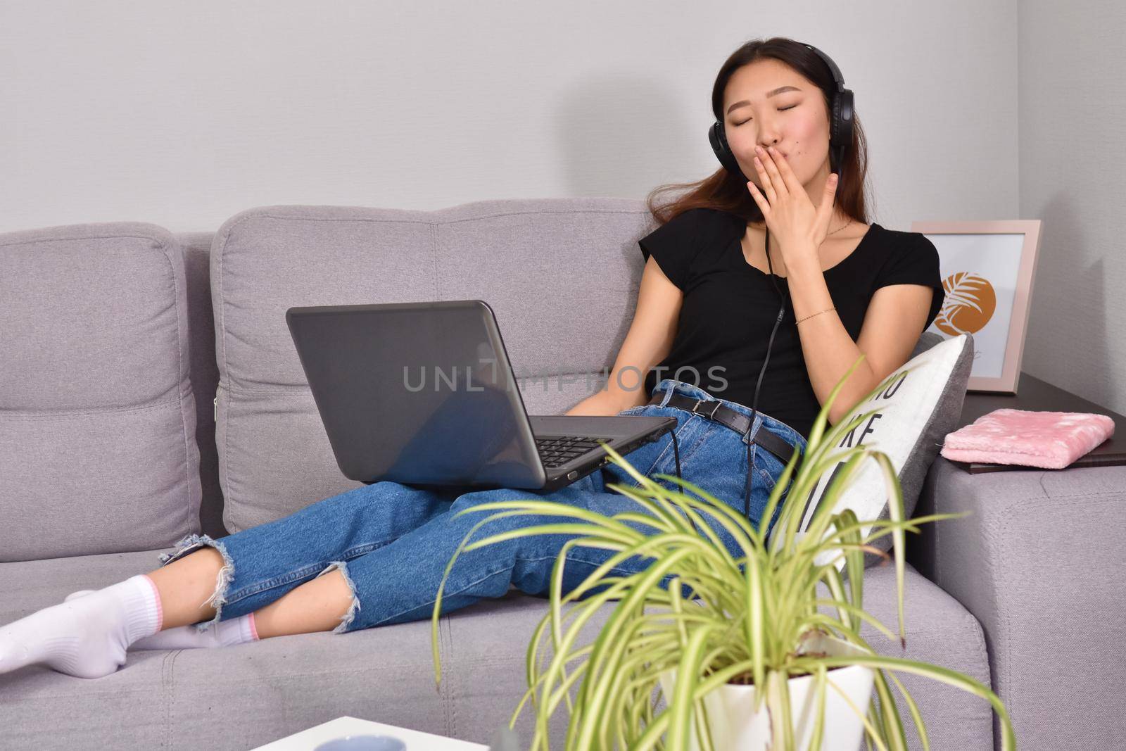 attractive asian young woman working with laptop and listening music at home