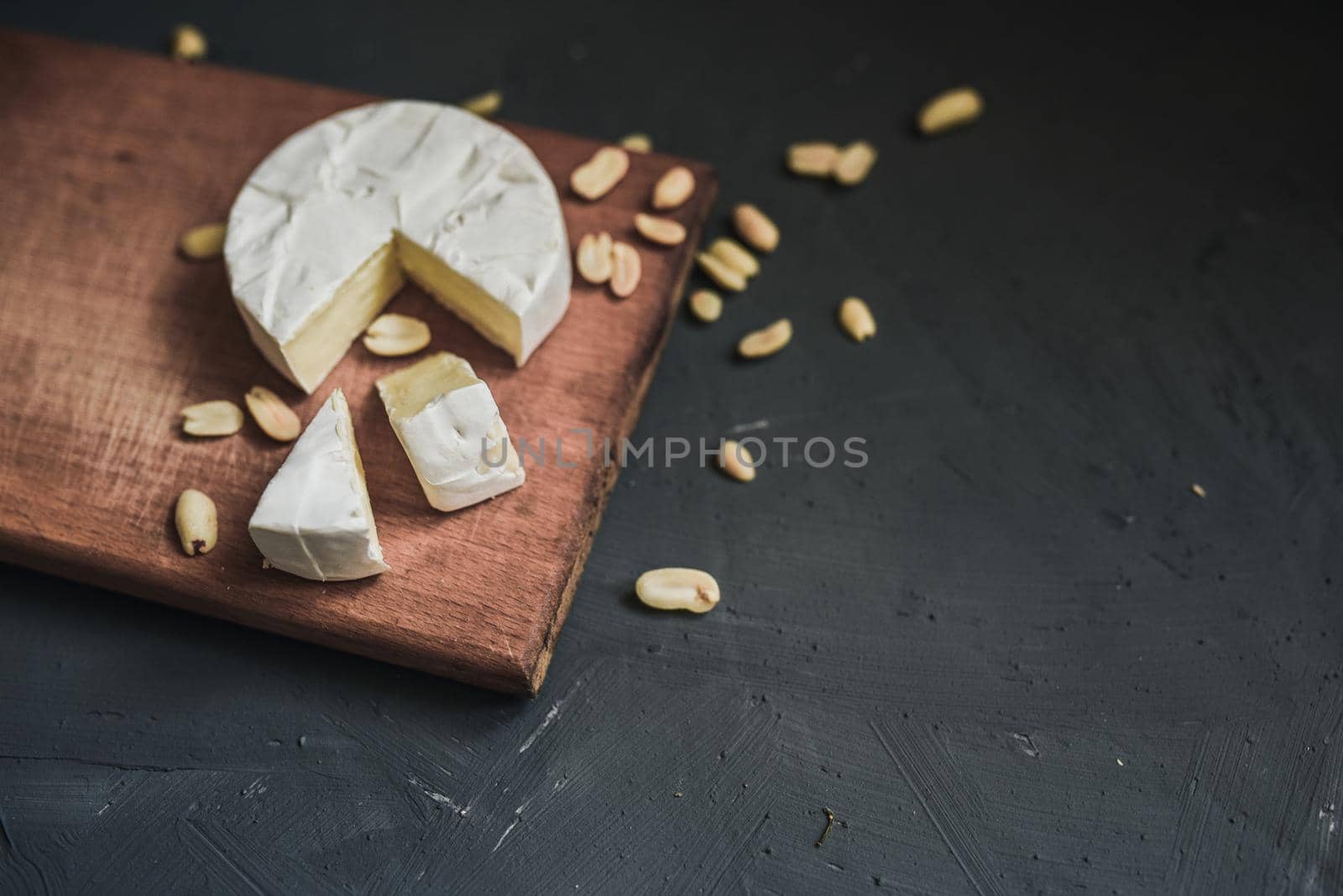 cheese camembert with mold and nuts on the wooden cutting board