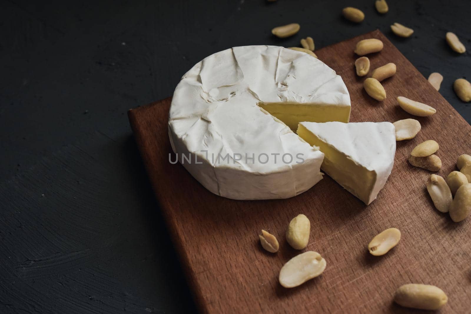 cheese camembert with mold and nuts on the wooden cutting board food