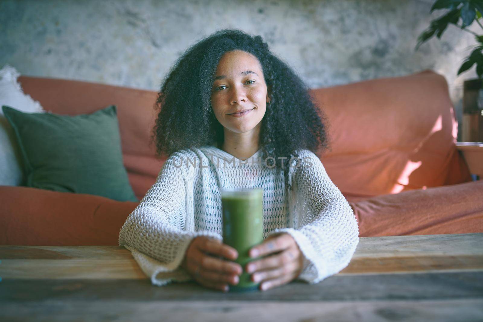 Portrait of you african girl smiling at camera with smoothie in her hand