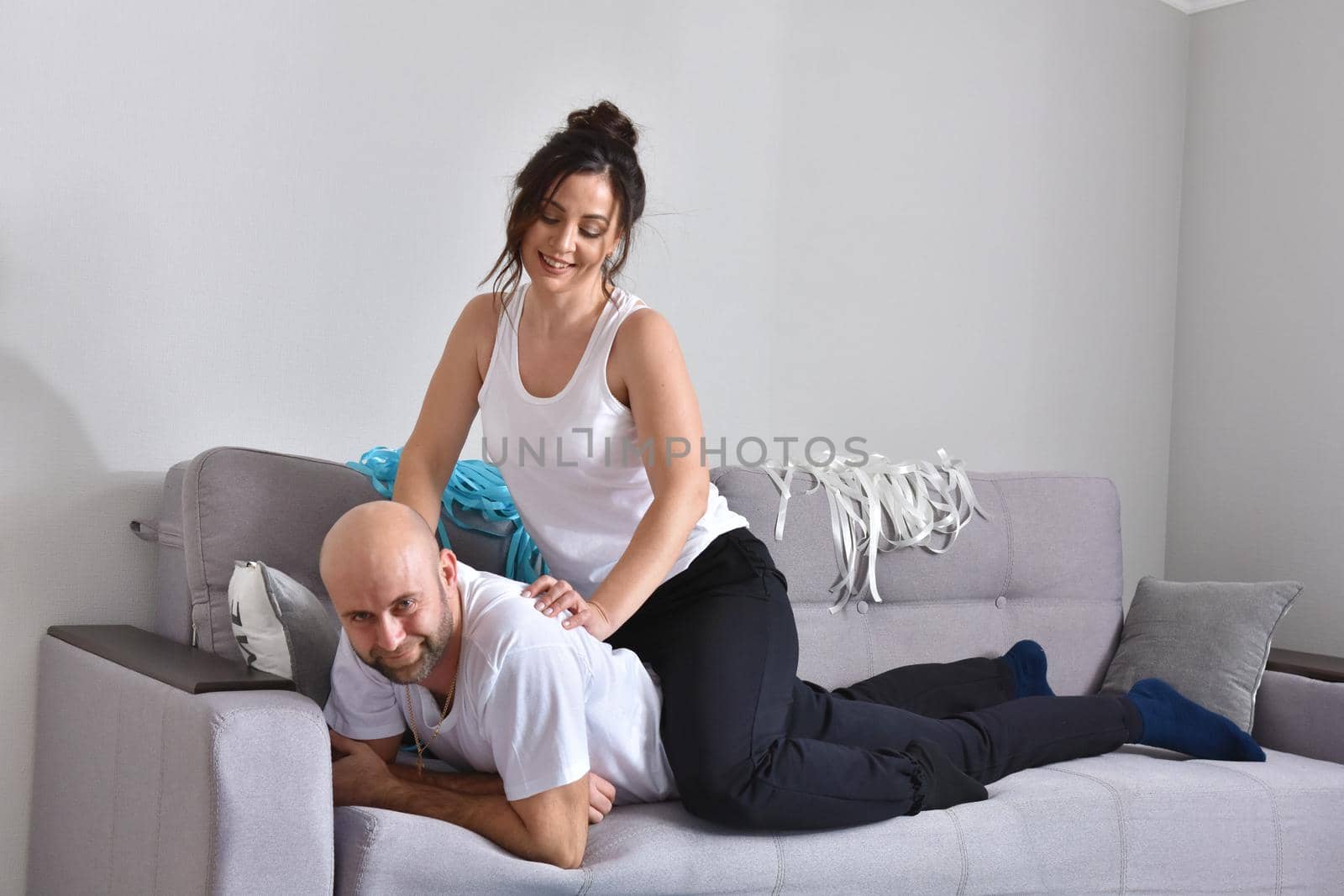 Family couple smiling ans hugging sitting on sofa by Bonda