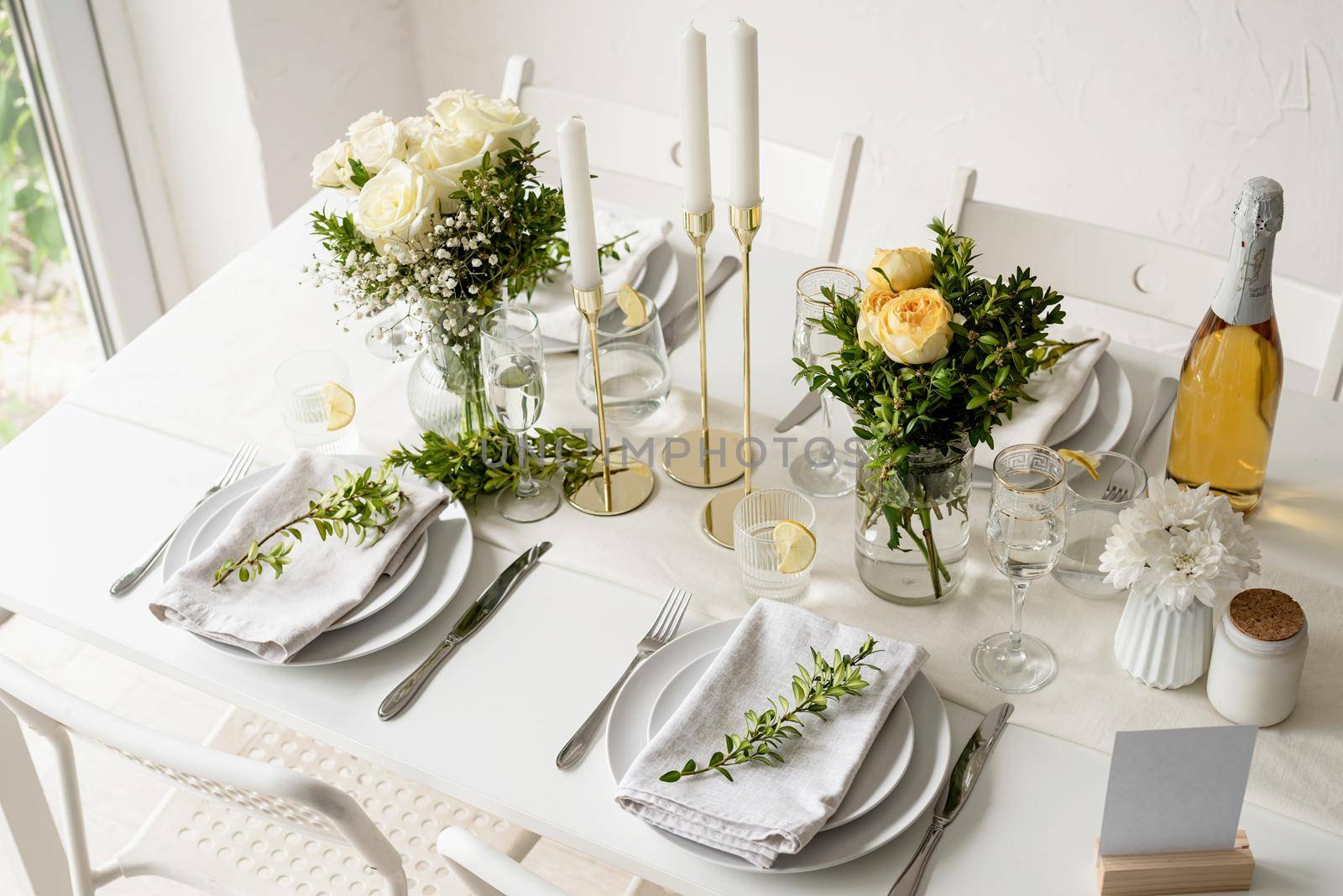 The wedding table setting, high angle view . Wedding teble decoration with white roses and boxwood by Desperada