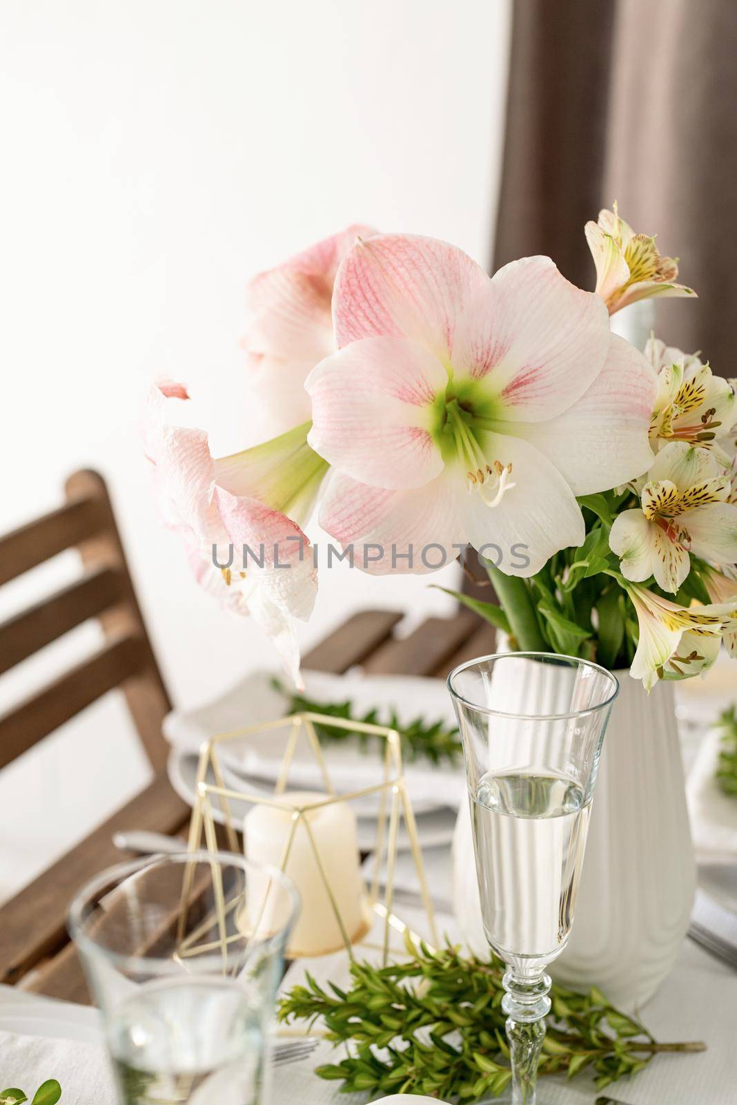 The wedding table setting and decor on wooden table in rustic style. Wedding table scapes. Table set up with boxwood and amaryllis flowers