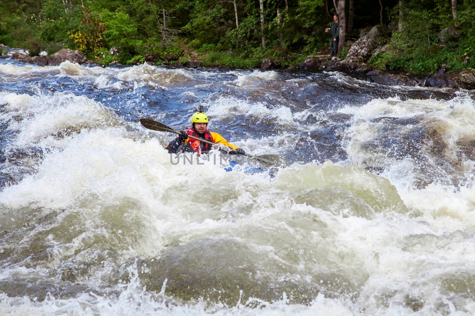 Kayaker in the whitewater on a river in Republic of Karelia, Russia