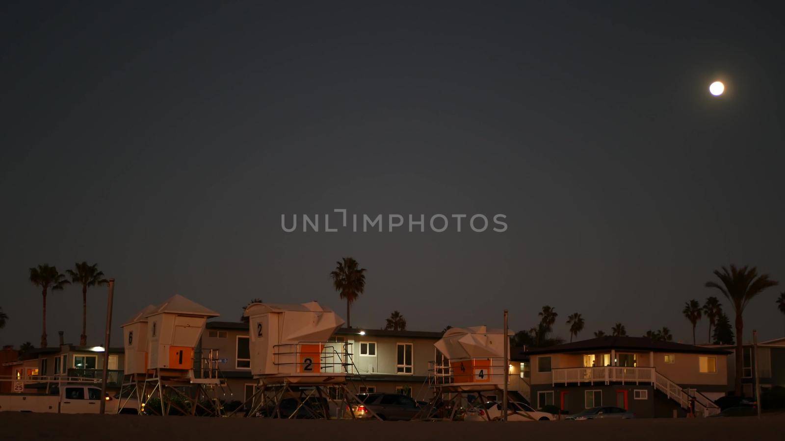 Palm trees and moon in twilight sky, California coast lifeguard, beach houses. by DogoraSun