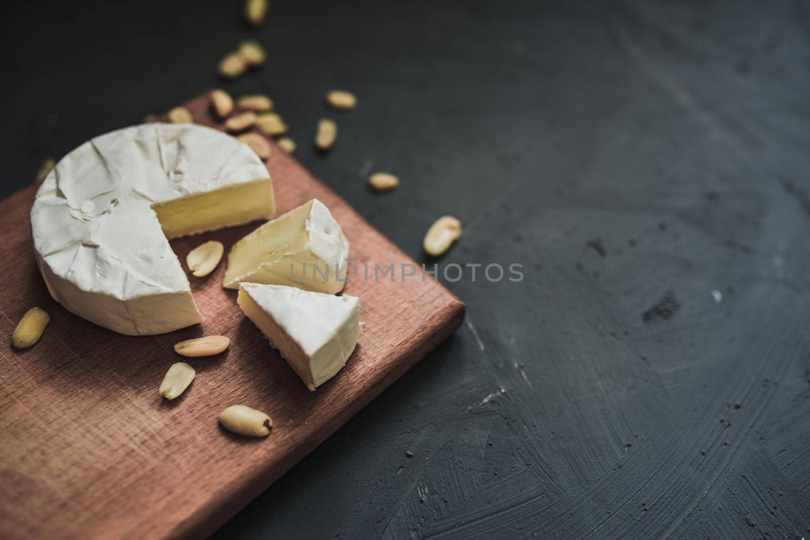 cheese camembert with mold and nuts on the wooden cutting board