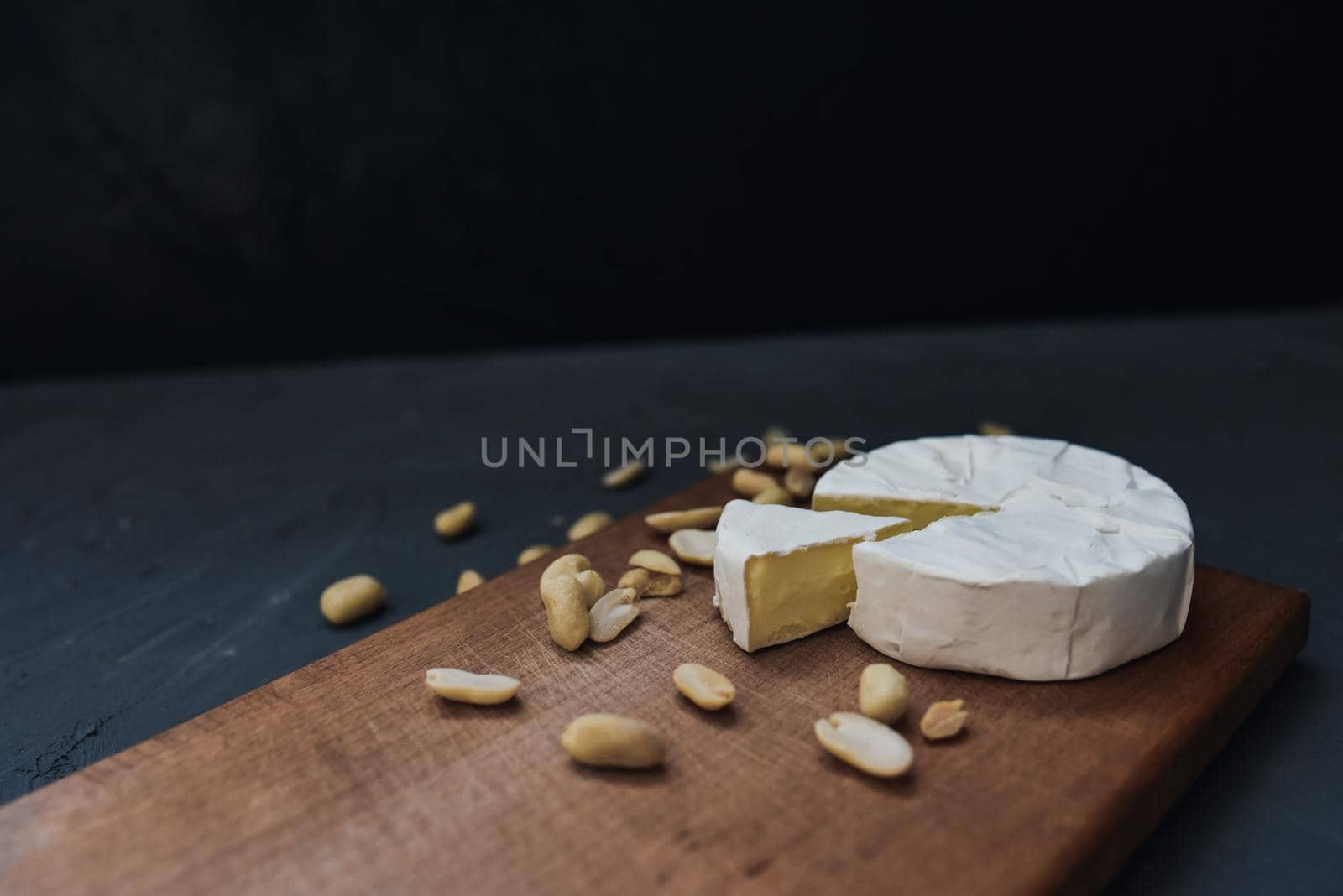 cheese camembert with mold and nuts on the wooden cutting board