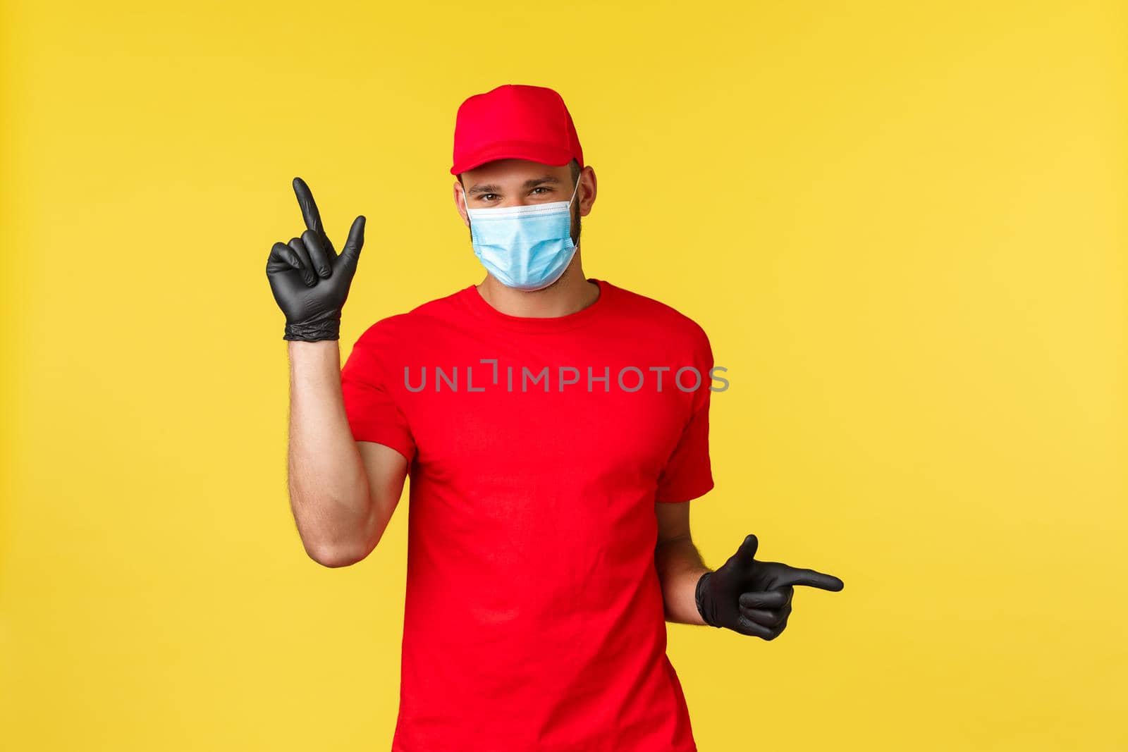 Express delivery during pandemic, covid-19, safe shipping, online shopping concept. Smiling cute courier in medical mask provide options for contactless package transfer, pointing left and right.