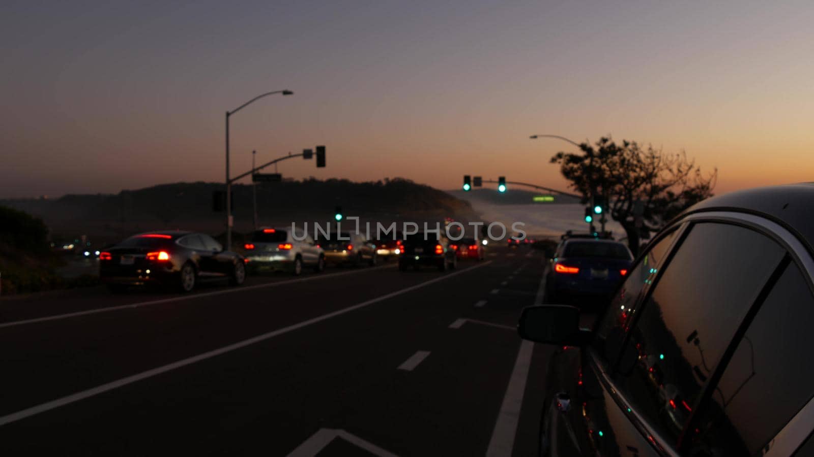 Traffic lights on pacific coast highway 1, Torrey Pines state beach, Del Mar, San Diego, California USA. Coastal road trip vacations. Roadtrip on freeway 101 along ocean. Cars in evening twilight dusk