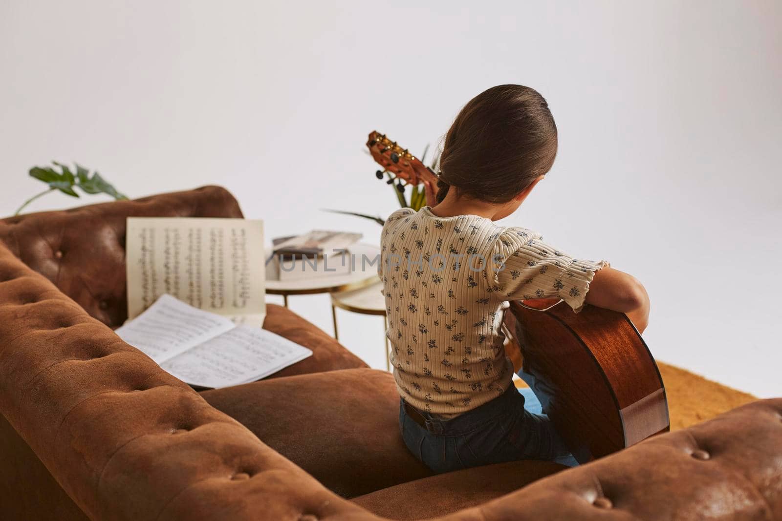 little girl learning how play guitar home